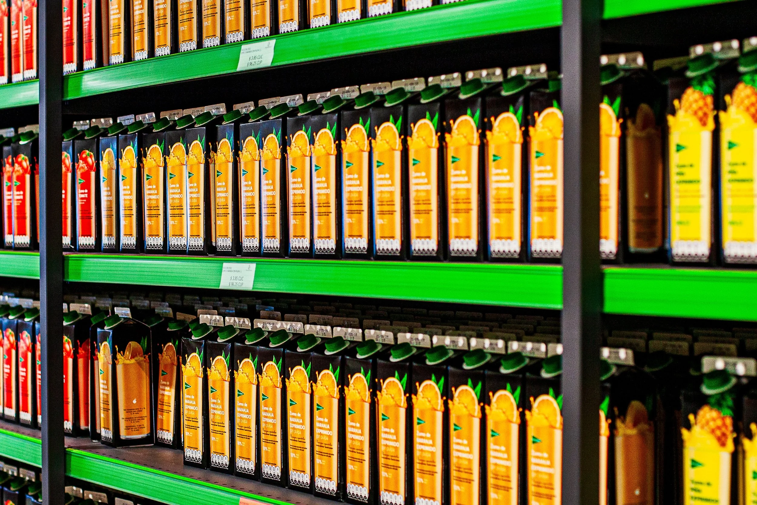 Detail crop from Repetition in Orange, emphasizing green shelving and small label changes interrupt the dominant warm color