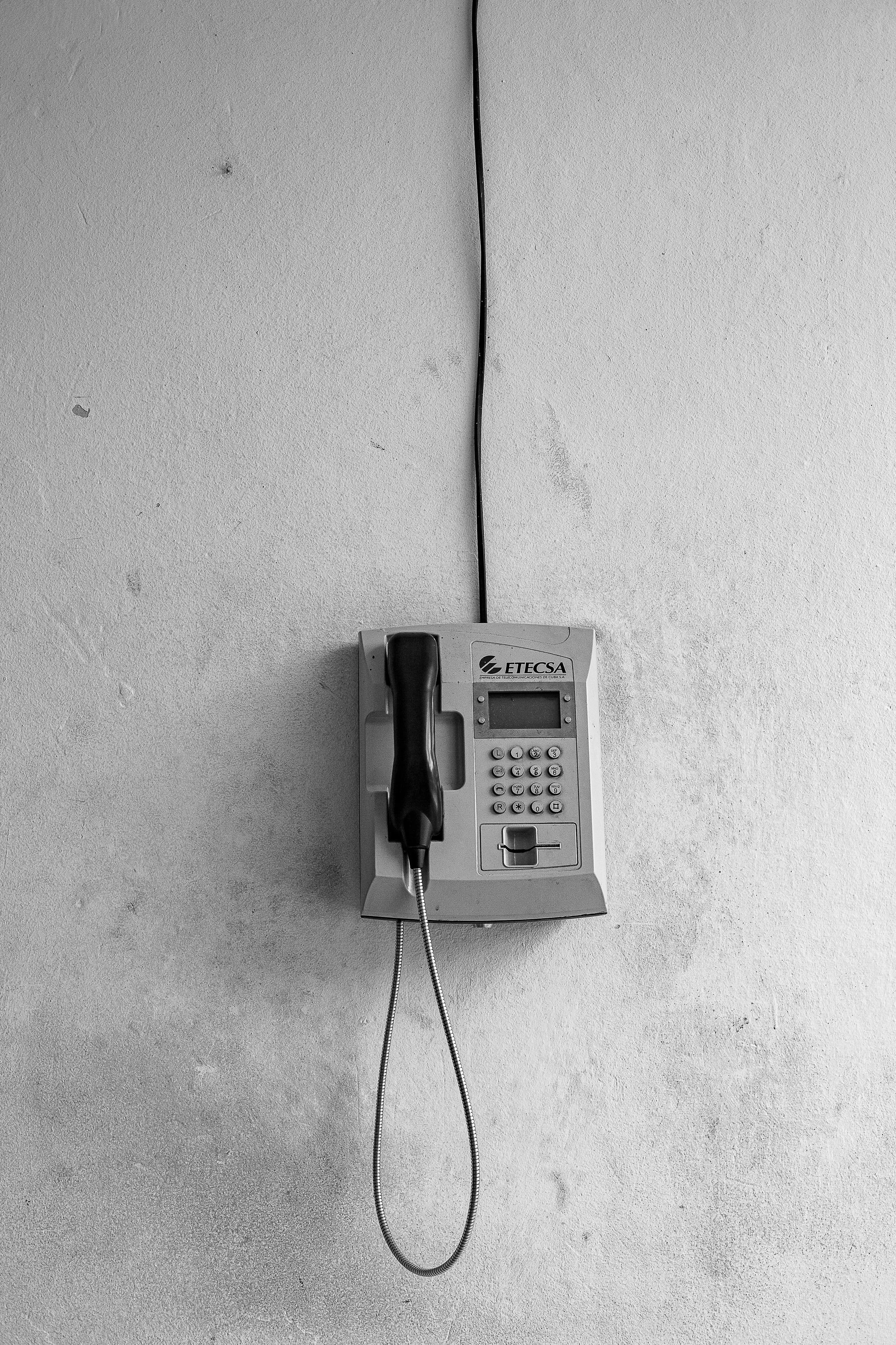 Complete uncropped artwork for Call Box, showing a simple wall telephone hangs alone on a pale surface in a narrow black-and-white view