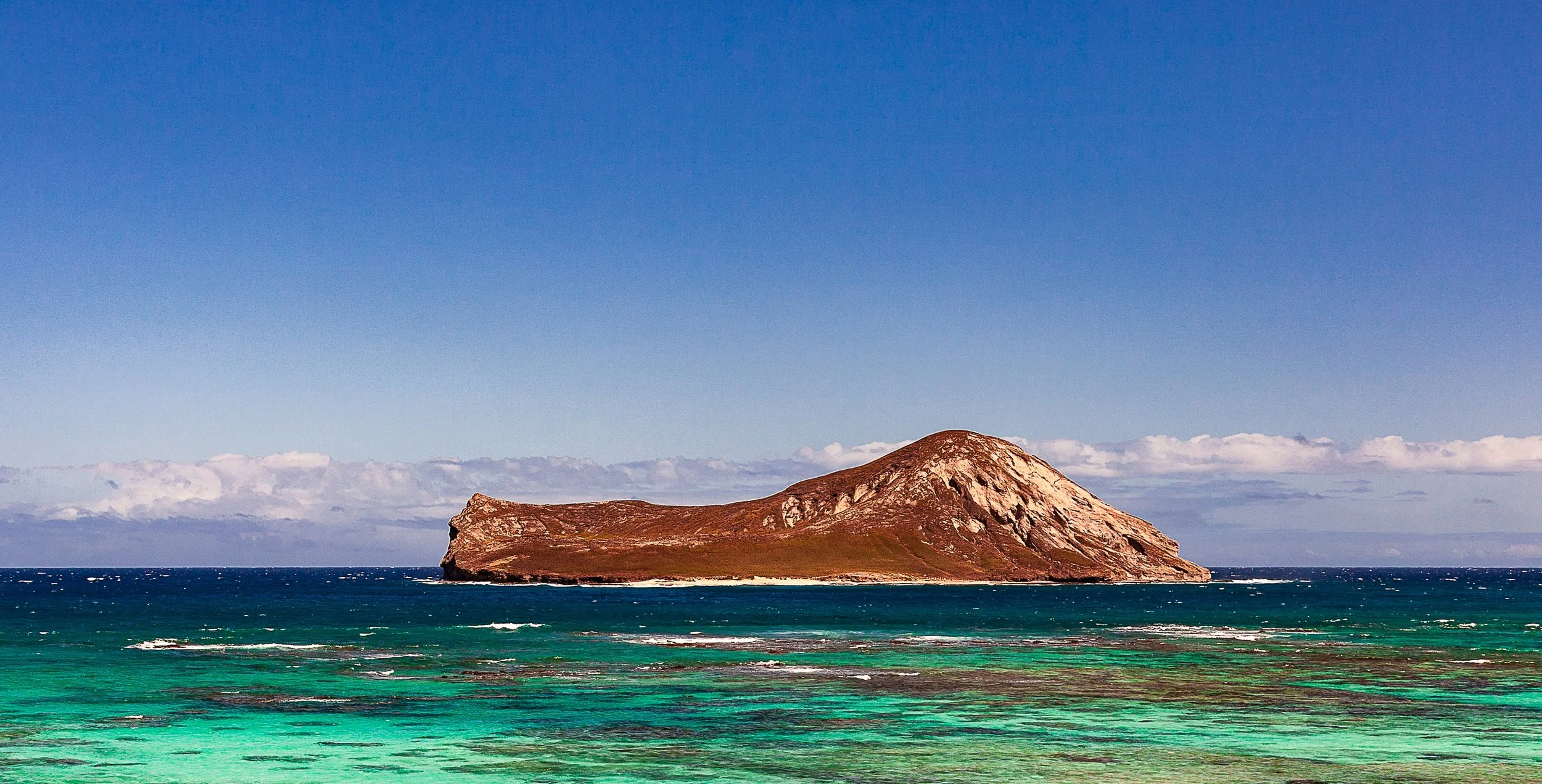 Complete uncropped artwork for Offshore Red, showing a rust-colored island rises from bands of turquoise and deep blue ocean