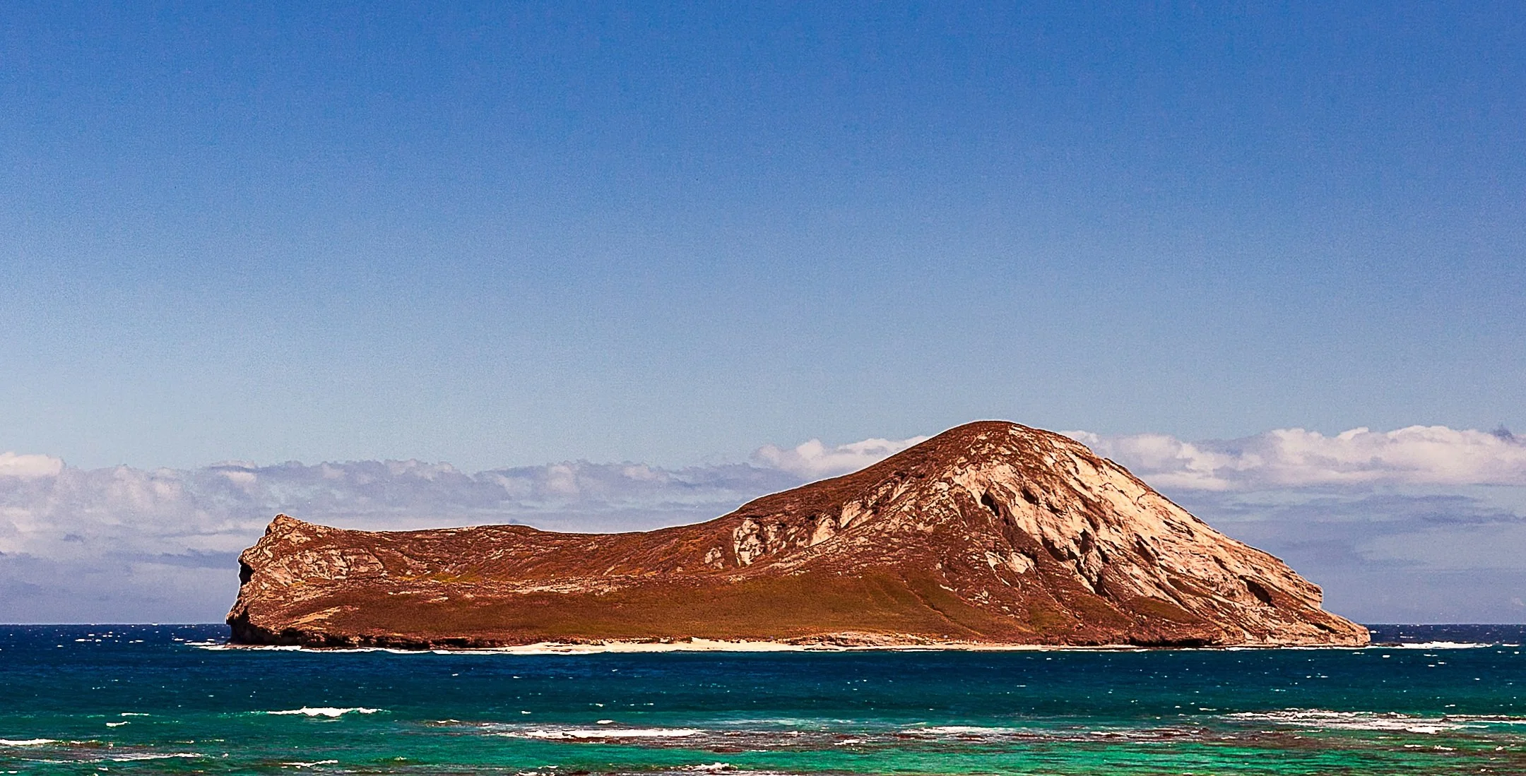 Detail crop from Offshore Red, emphasizing reef lines and distant clouds create several separate horizons around the island
