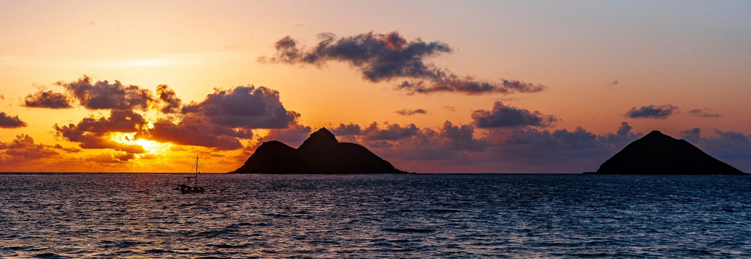 Complete uncropped artwork for Islands at Sunset, showing two dark islands sit beneath a warm sunset reflected across open water