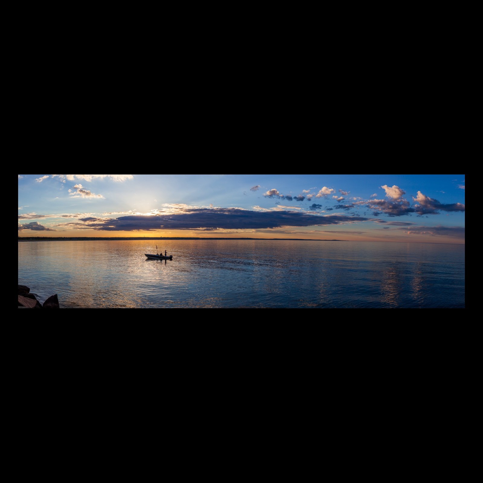 Full-frame black presentation thumbnail of Boat on Still Water, showing a small boat rests on reflective water beneath a long layered evening sky