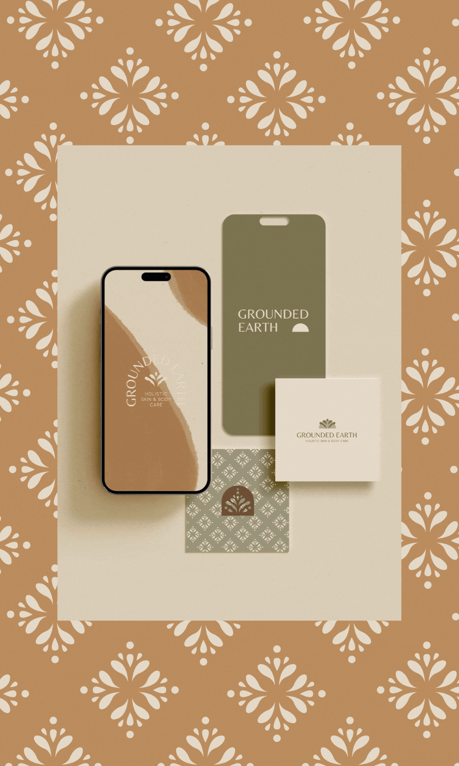Flat lay of skincare products with phone, box, and packaging on decorative background featuring beige, brown, and white floral pattern. The products are labeled 'Grounded Earth'.