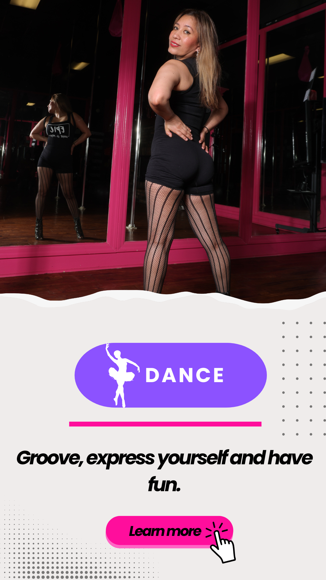 A woman in a black dance outfit and fishnet tights posing in a dance studio with pink-framed mirrors, smiling at the camera.