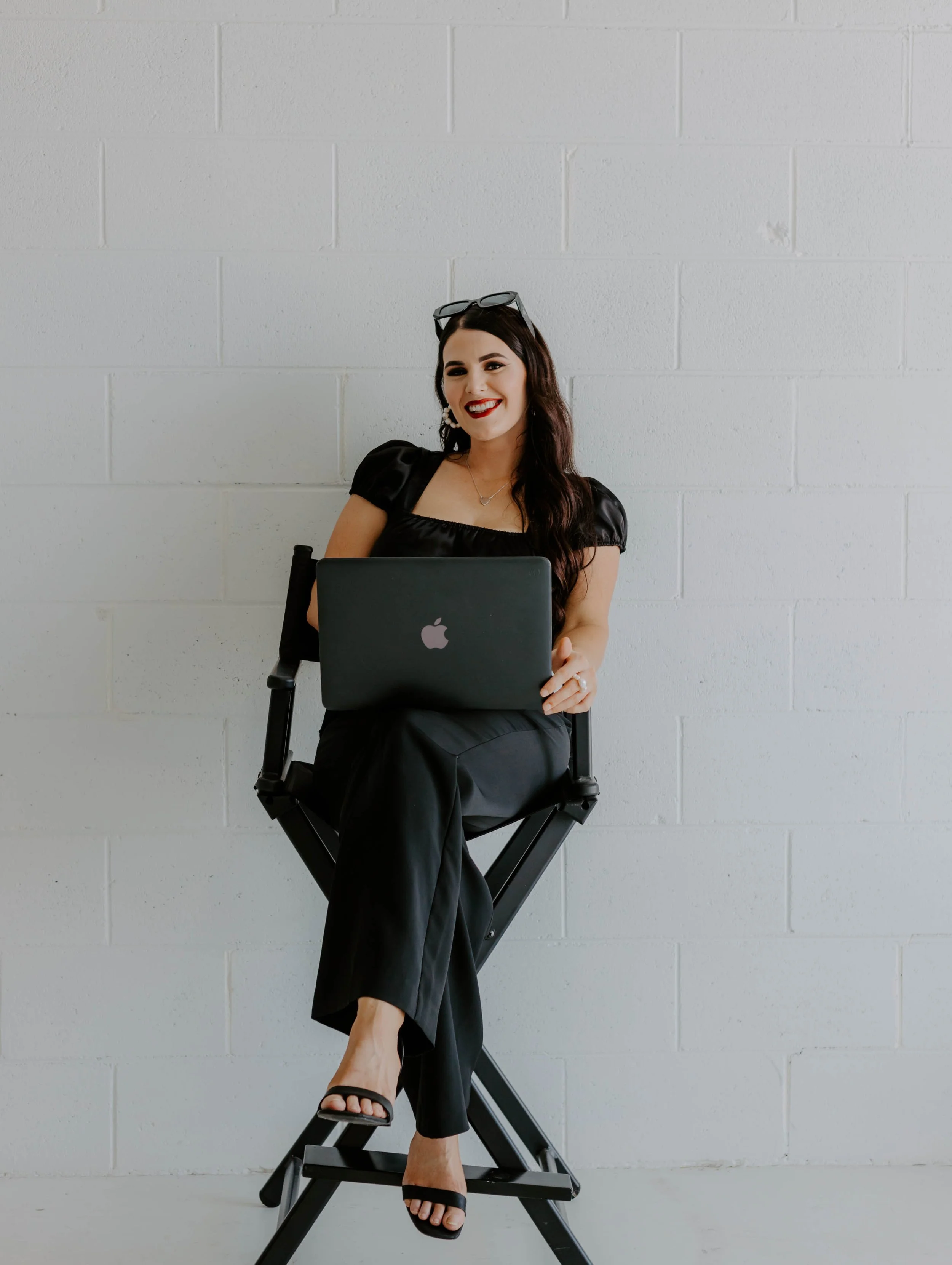 Lysha, owner and founder of Sugar and Spice Event Co., sitting with laptop at Rockhampton event space