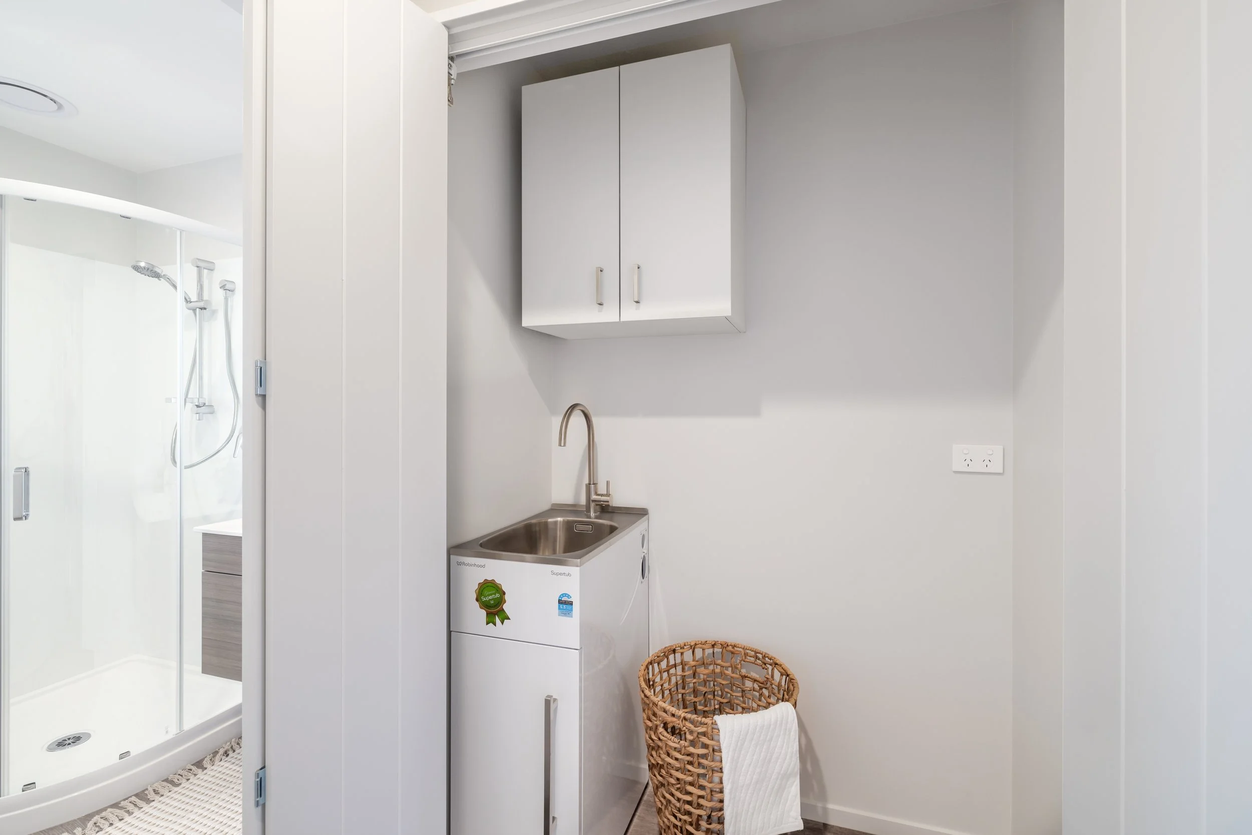 Laundry behind bifold doors, space optimisation. Built in Christchurch by Dennehy Construction.