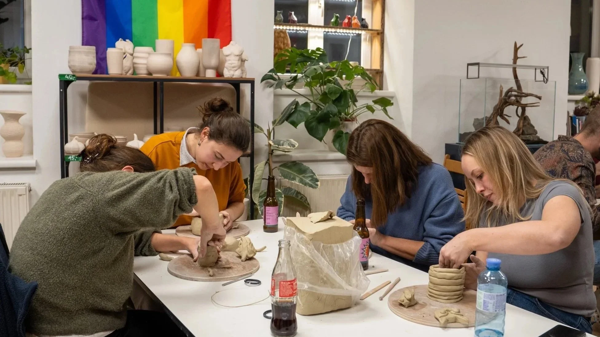 Menschen beim Töpfern in einem Kunststudio, mit verschiedenen Töpferwaren auf die Regale im Hintergrund