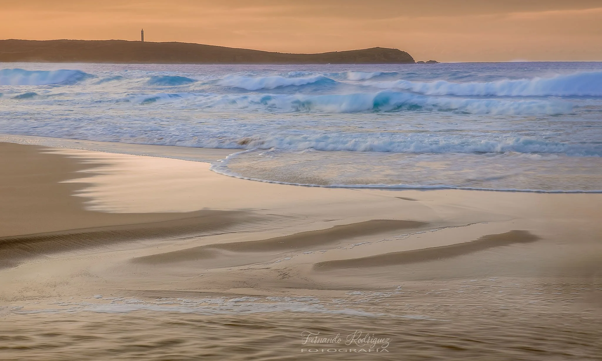 Vista general de la playa de Pantín, Valdoviño, con oleaje y con el Faro de A Frouxeira en el horizonte