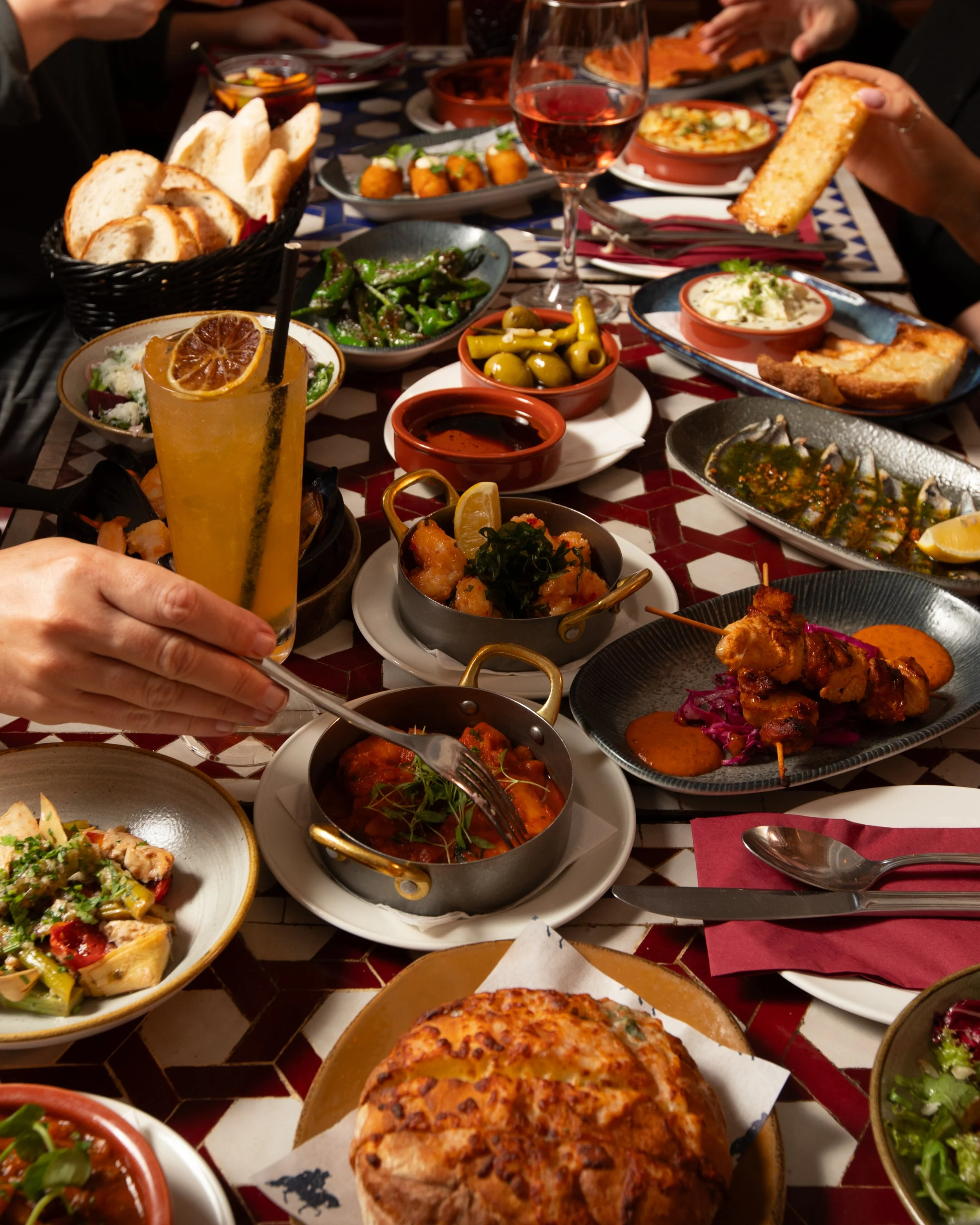 group of friend sharing lots of Spanish tapas dishes