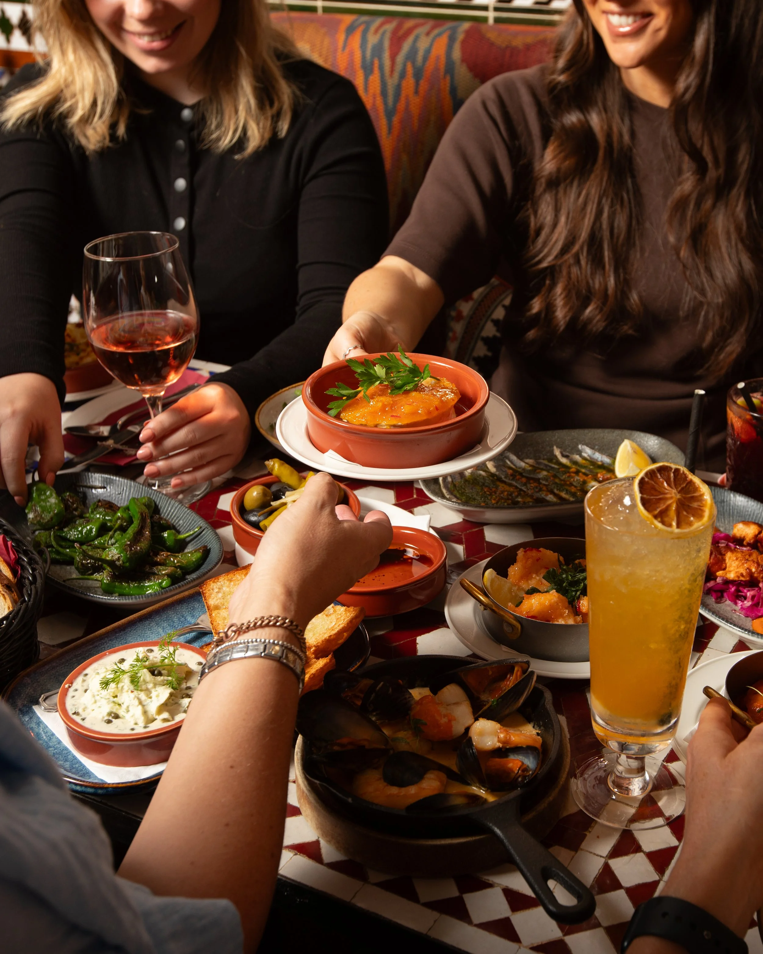Friends at table sharing lots of Spanish tapas dishes
