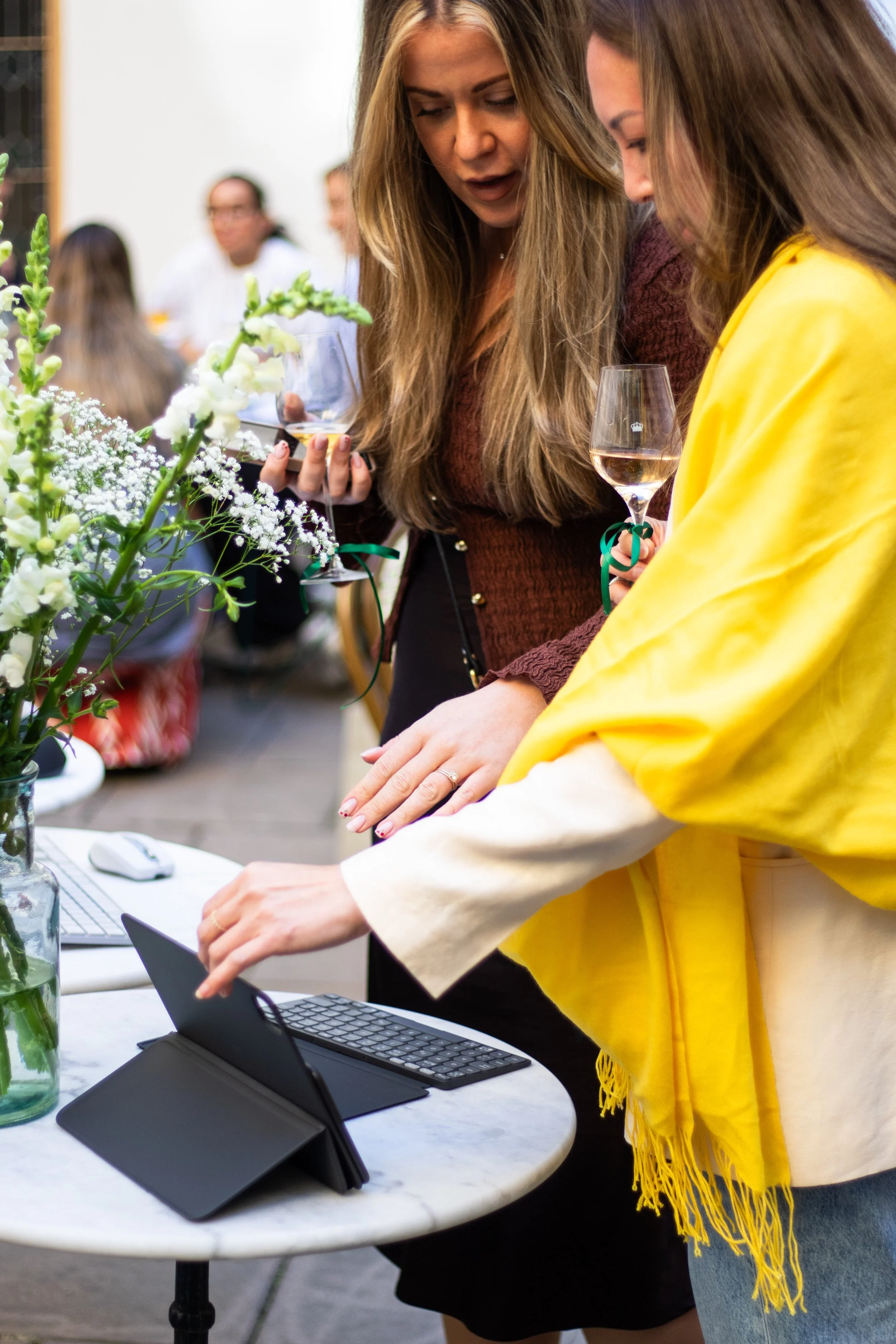 Event photography in Stockholm. Outside venue, sunny after-work event for a tech-company. Swedish influencer hosting with branded drinks and goodie-bags for guests. Guests looking at newly released tech products.