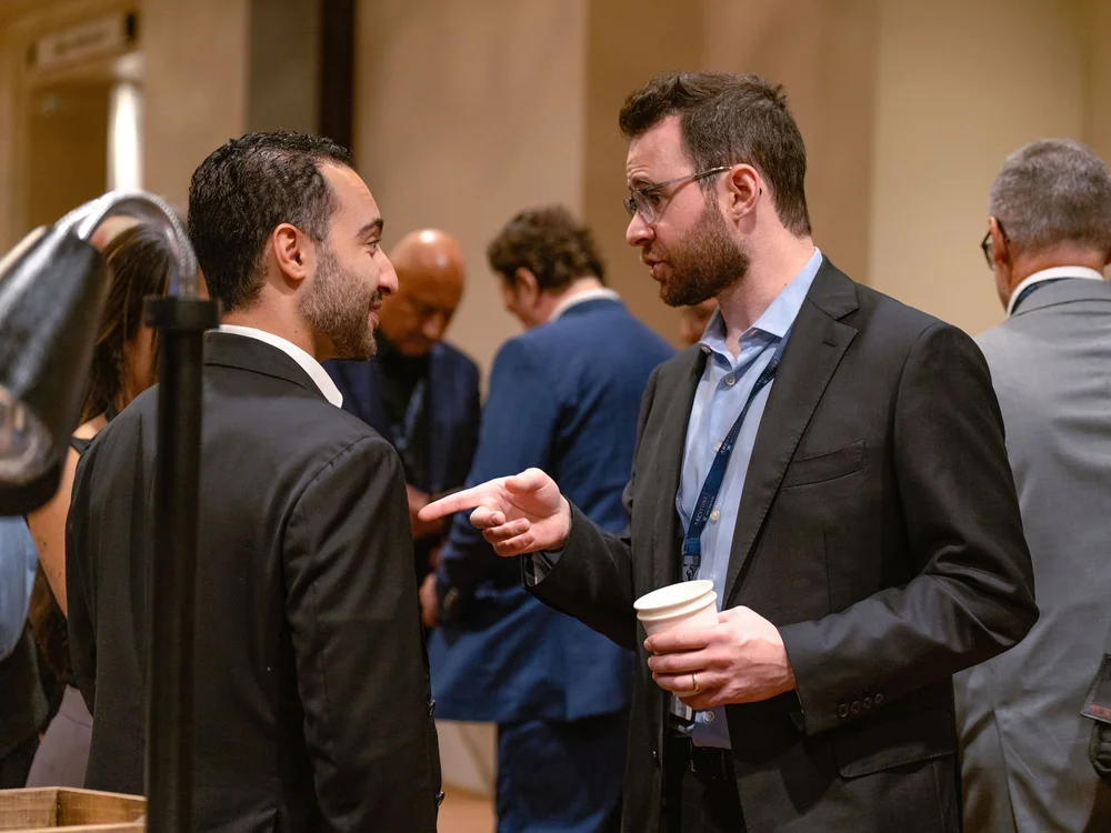 Attendees in conversation in the foyer