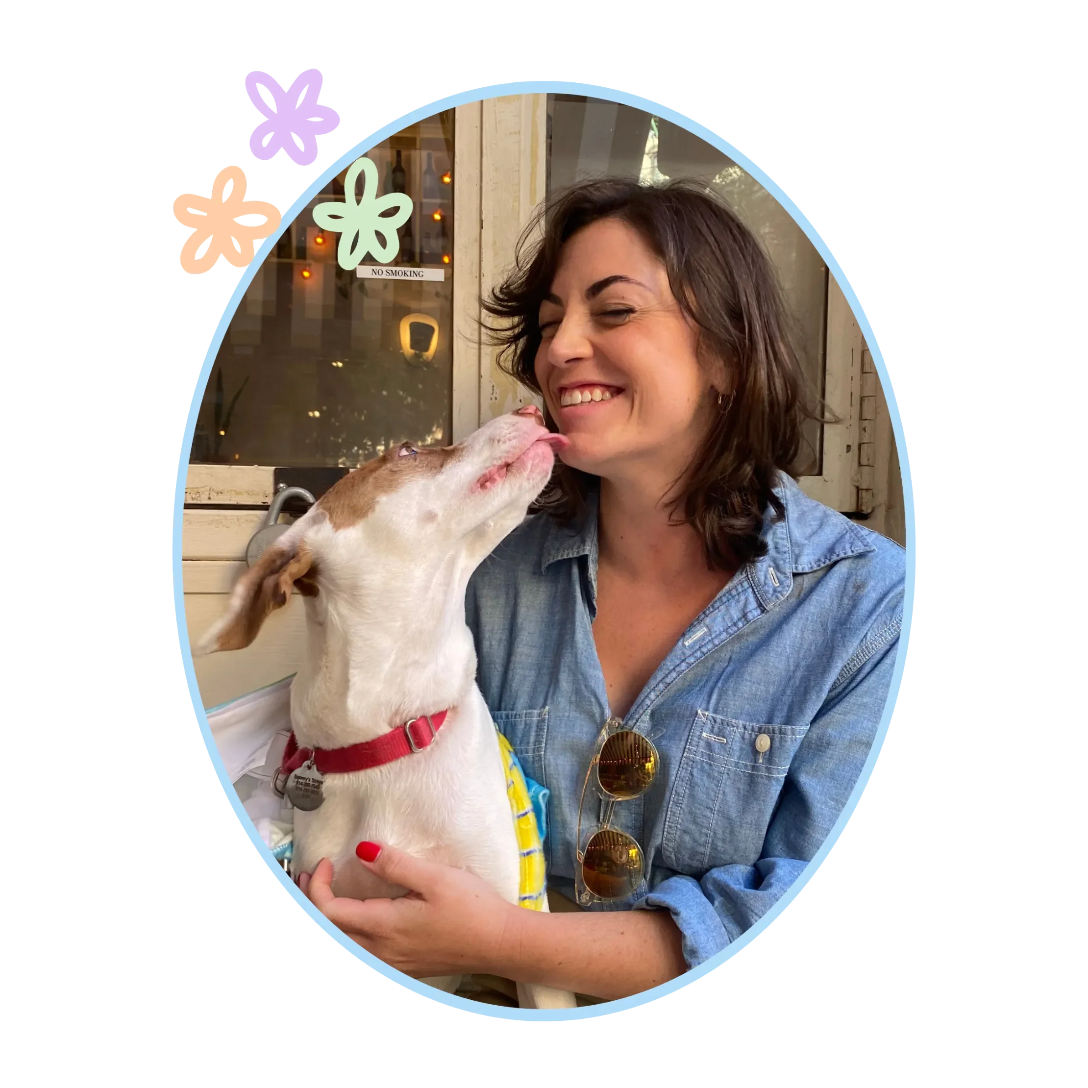 Lauren Sisak, UWS dog trainer and owner of Sit. Stay. Stella. being licked in the face by her white and brown dog Stella