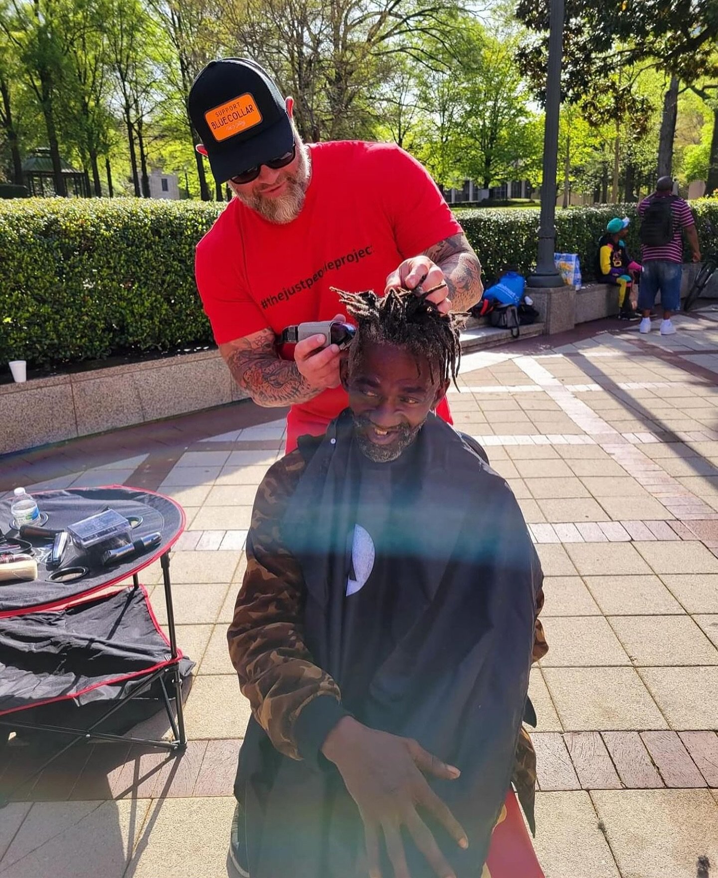 Chris (@thehomelessinbirmingham), founder of The Just People Project, spreading smiles and giving haircuts to the homeless at an outdoor park event. @thejustpeopleproject is a nonprofit organization focused on serving the homeless in Birmingham with 