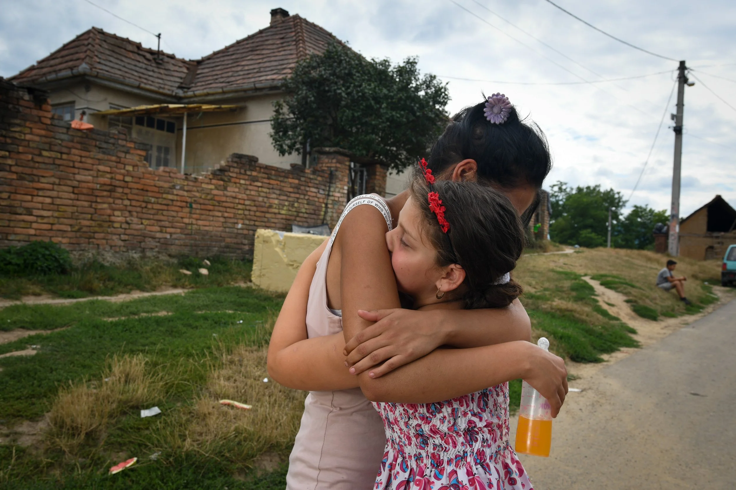  Evelin hugs her cousin in front of their house located in the Roma settlement in Drégelypalánk, Nográd county, Hungary. 