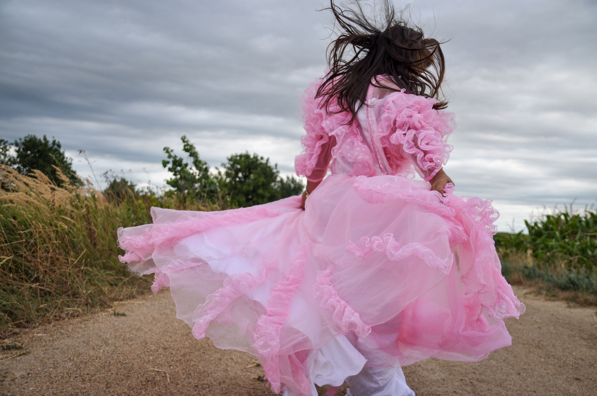 A little girl dances in her most beautiful dress at the village border in Pacsatüttös, Western-Hungary.
