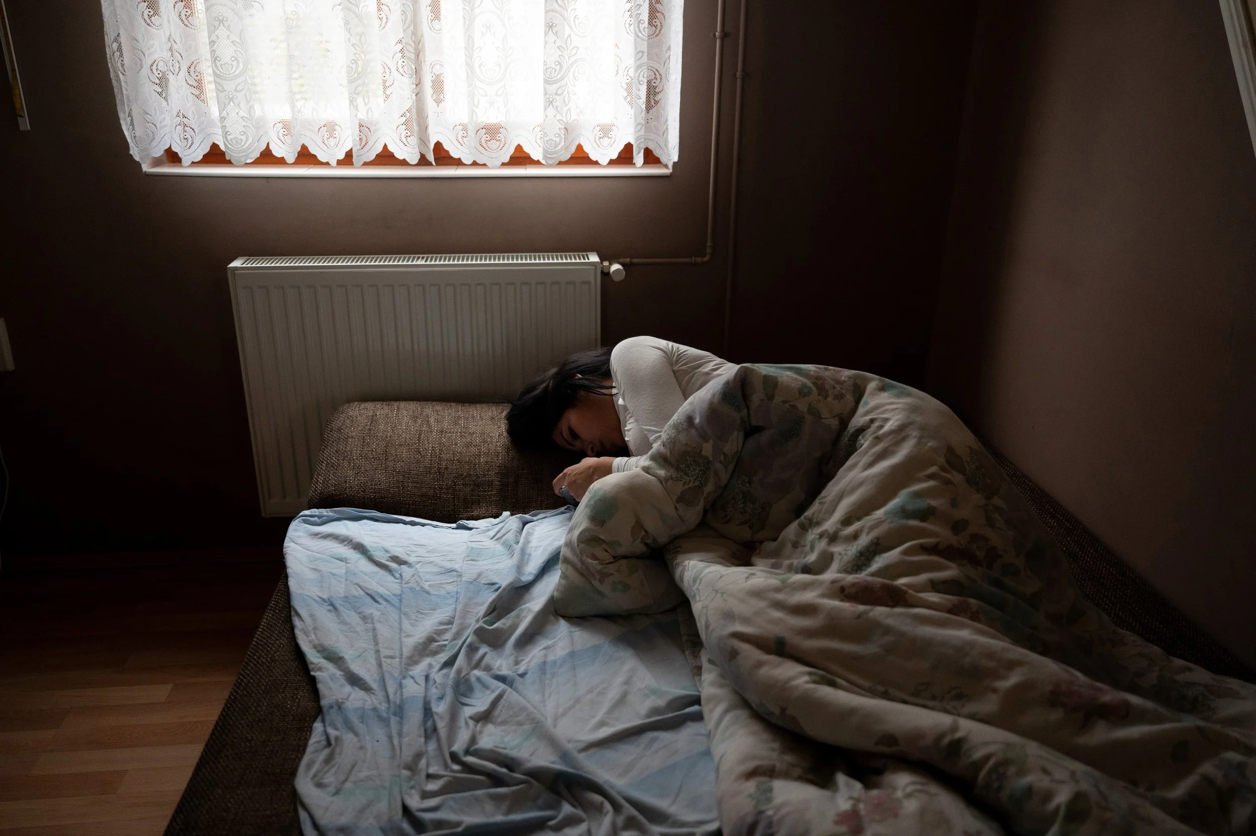  Evelin is relaxing on the sofa in their home. 