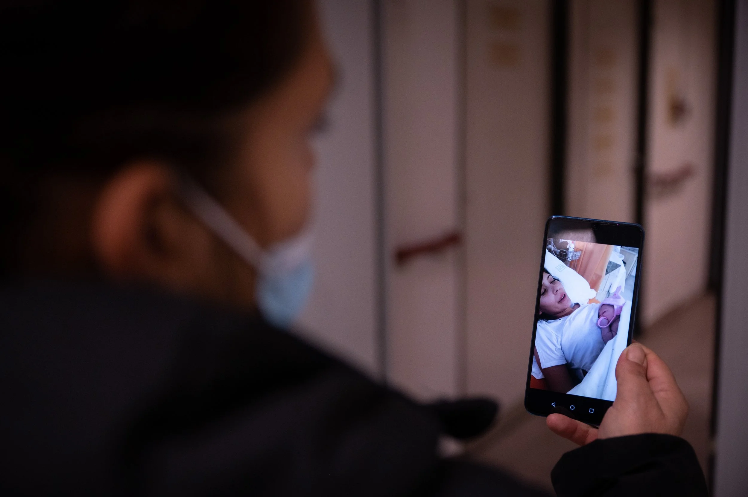  Bogi shows a photo of her seventh grandchild to her relatives in a video call outside the delivery room. 
