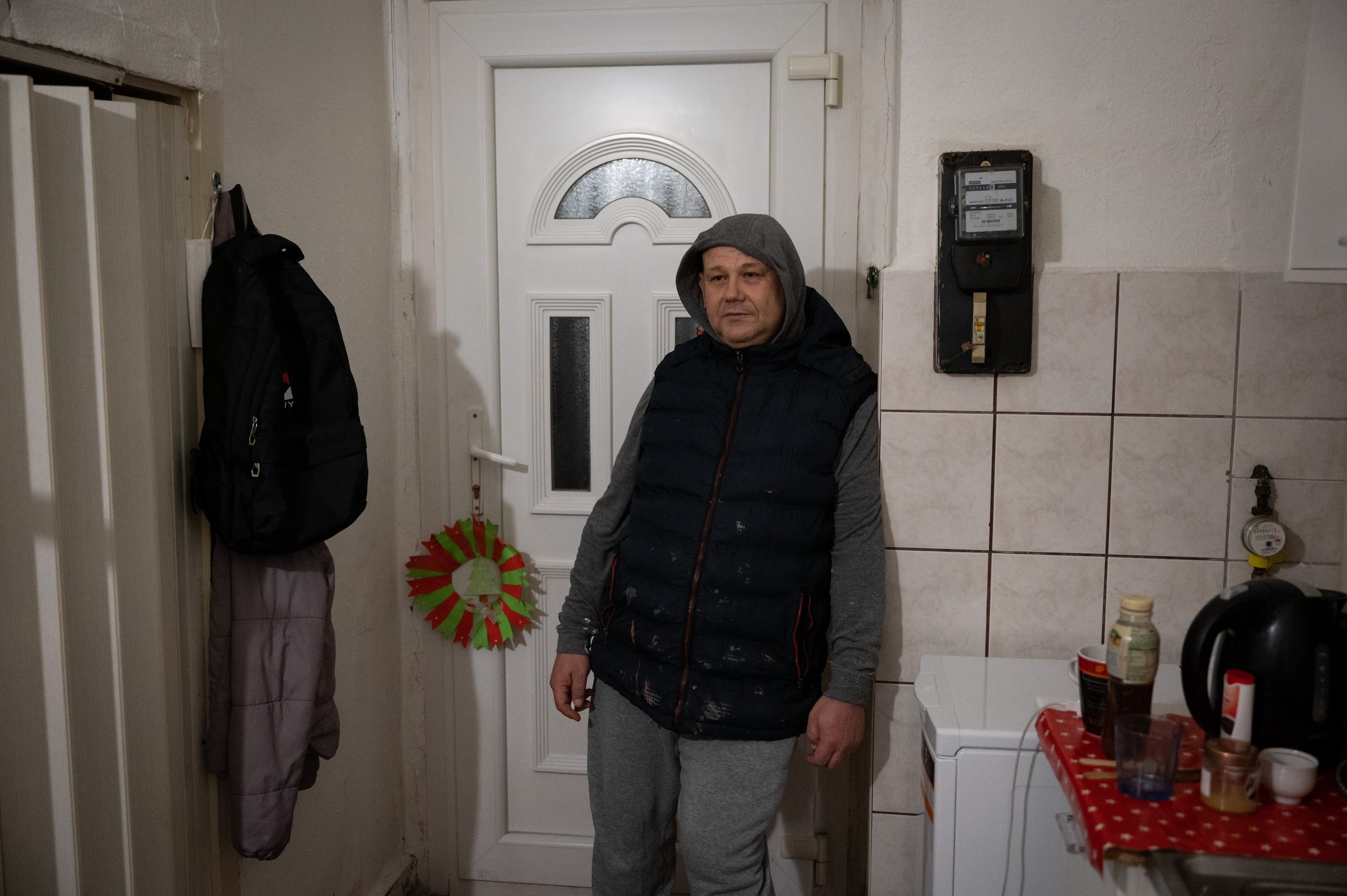 Mihály rests in their kitchen after a long day at work.