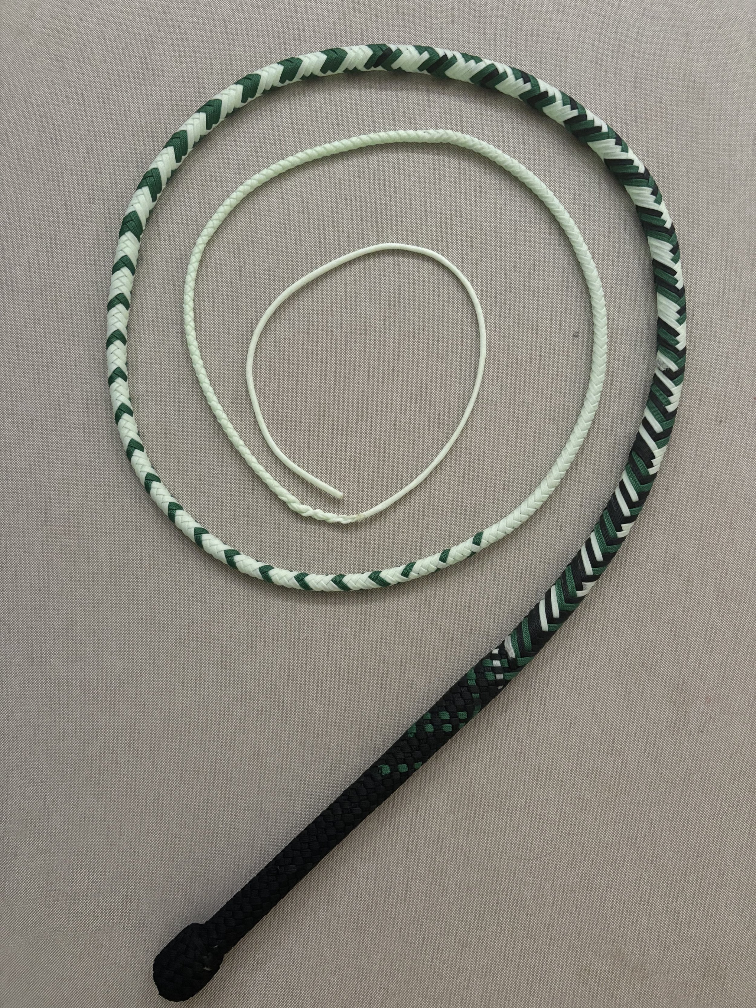 Three lanyard necklaces of different sizes and colors arranged in a spiral on a gray background.