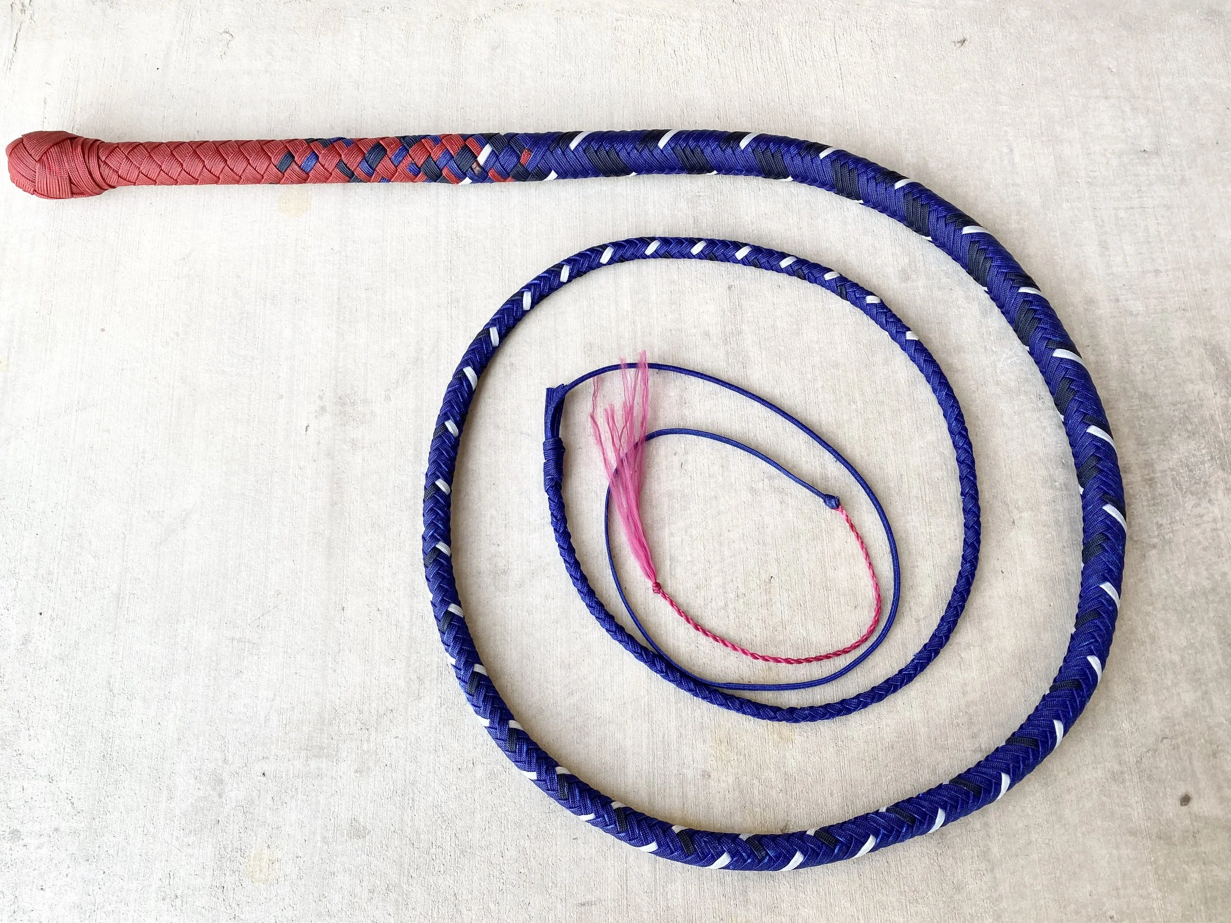 Colorful jump rope with a pink and blue pattern, arranged in a spiral on a light-colored surface.