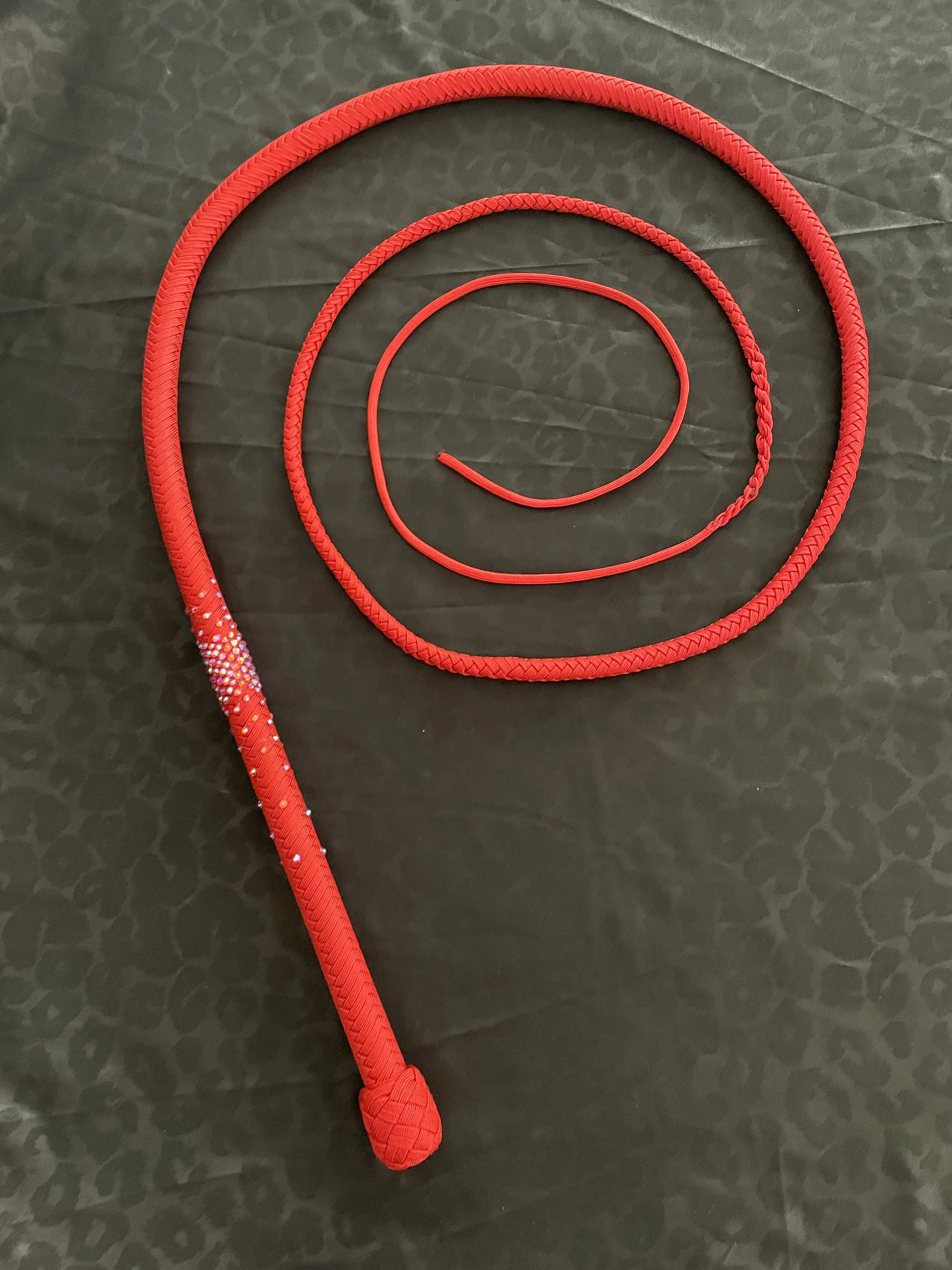 "Raquel's Whip" 6f Stardust Bullwhip featured at the Sin City Burlesque Festival, named after the producer of the festival, Raquel Reed.  This whip was inspired by one of her red costumes and is encrusted with gems that also bear her namesake.