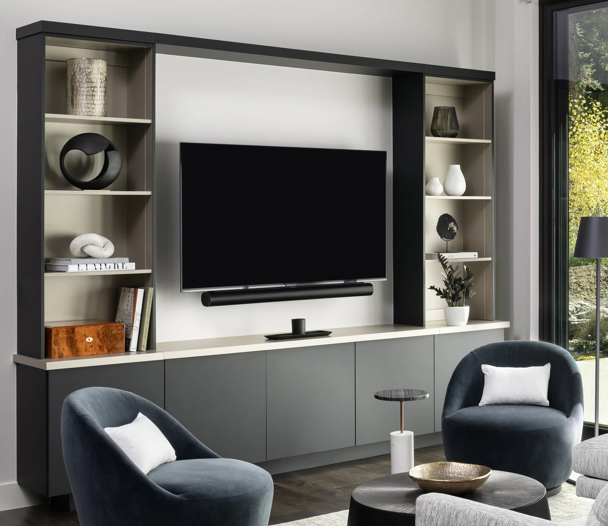 Built-in media wall styled with books, artwork and decorative objects with open space between pieces.
