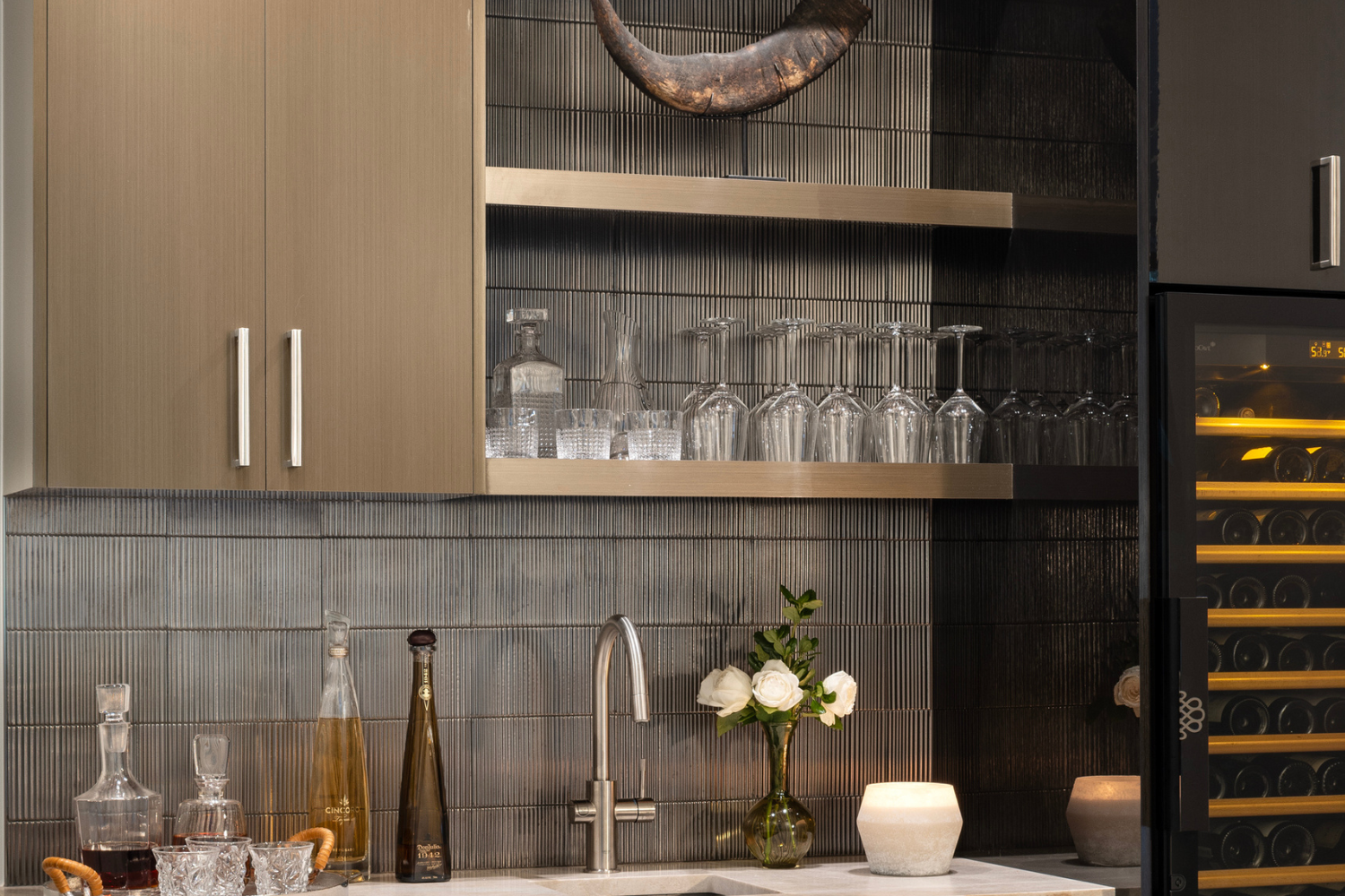 Custom bar with layered materials, textured backsplash, and warm lighting creating depth and contrast