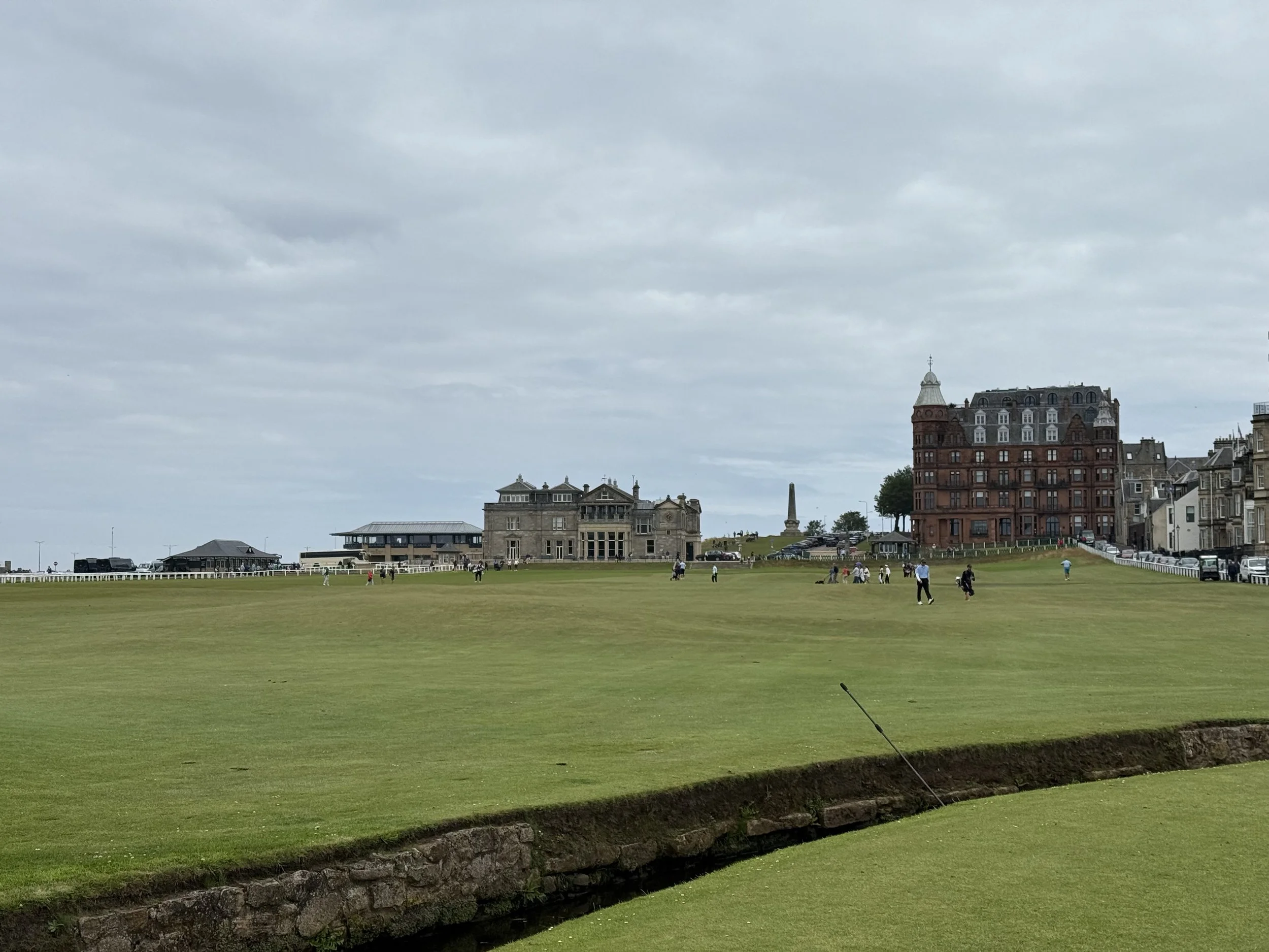 St Andrews Links view from Swilcan Bridge to 18th green with R&A clubhouse and Hamilton Grand behind.