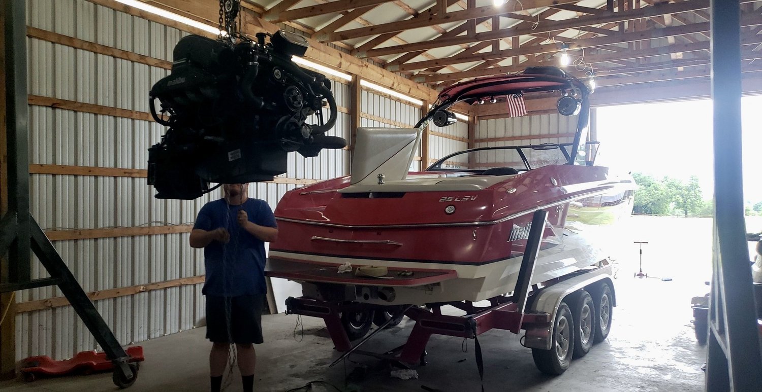 Engine lifted out of a boat during mechanical service