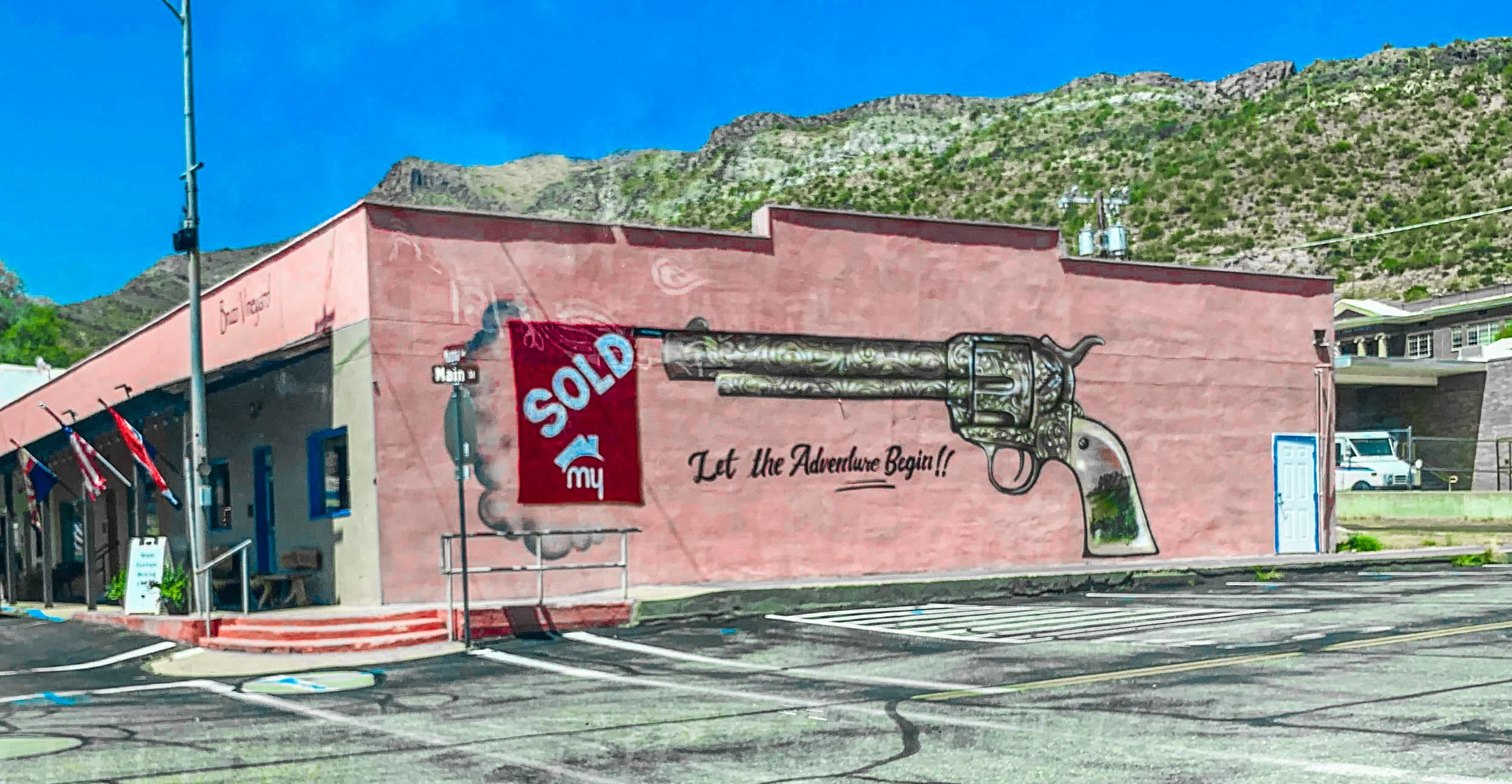 An adobe building in downtown Superior, Arizona with a gun mural.