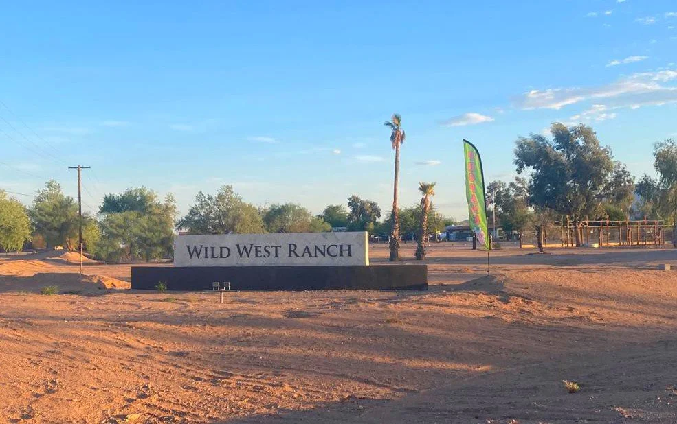 Wild West RV Ranch roadside sign along Highway 84 near Stanfield, Arizona, surrounded by Sonoran Desert scenery.