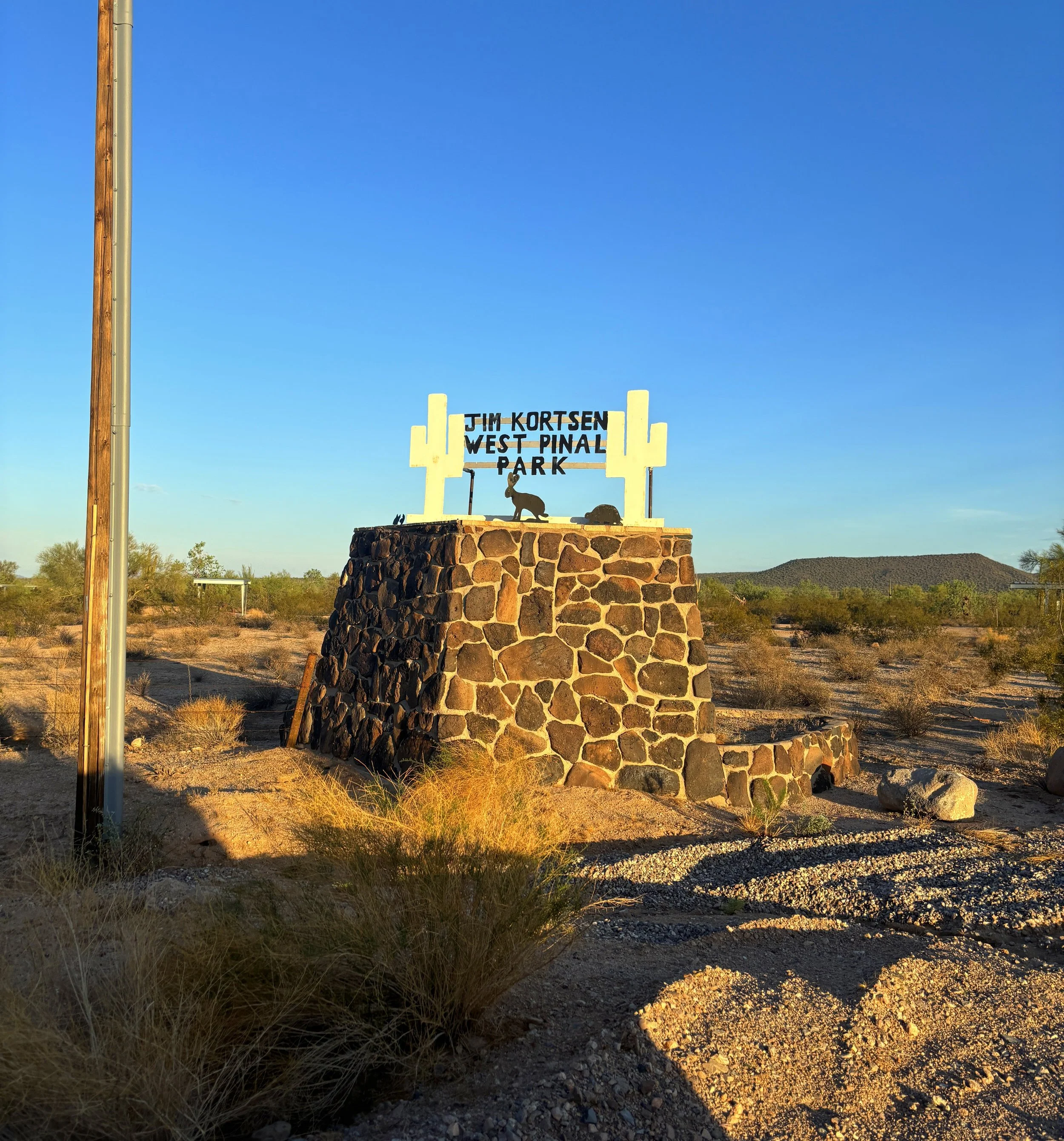 Jim Kortsen West Pinal County Park entrance sign along Highway 84 near Stanfield, Arizona, surrounded by Sonoran Desert scenery.