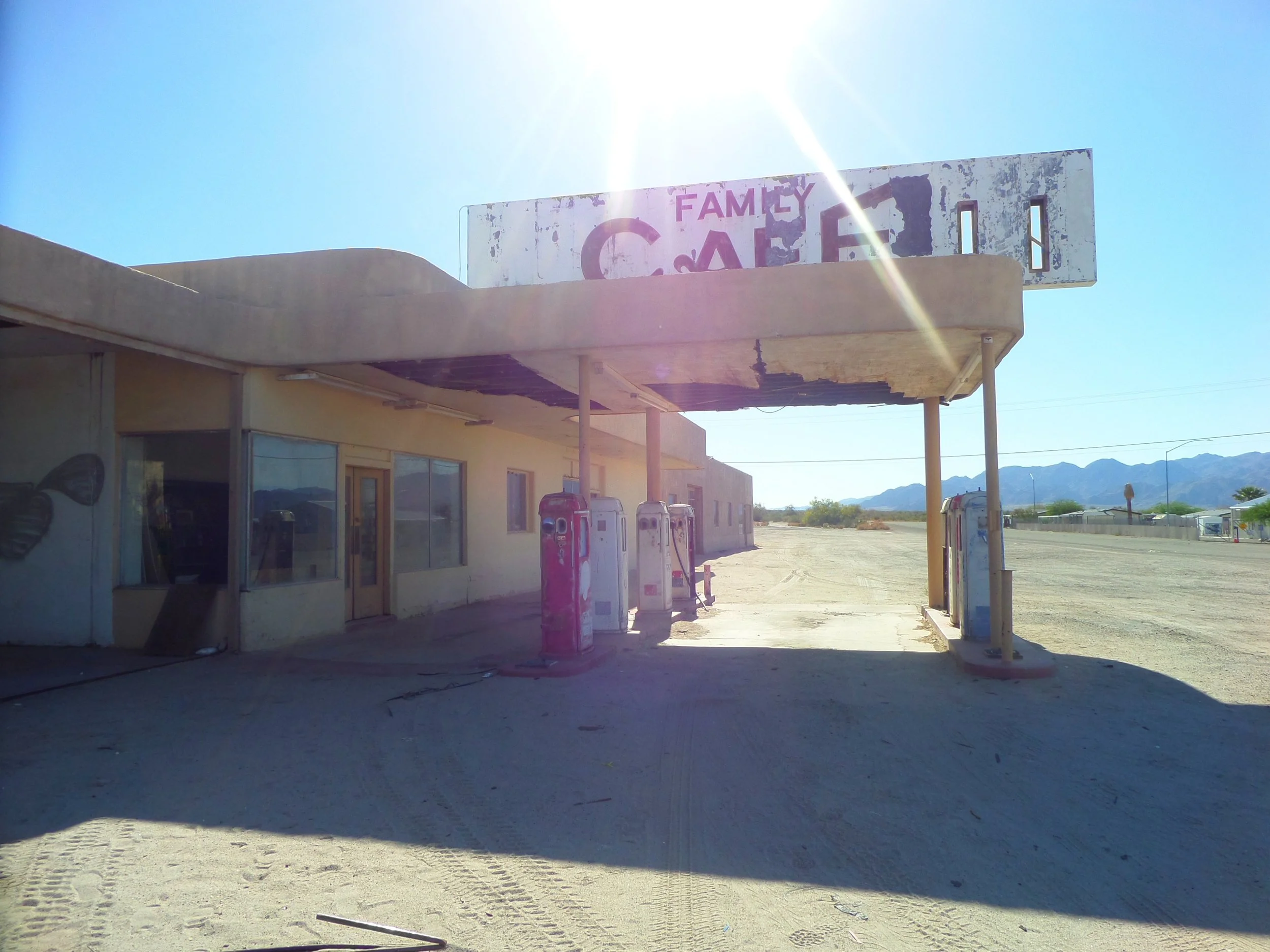 Abandoned Family Cafe with vintage gas pumps in Desert Center, California.