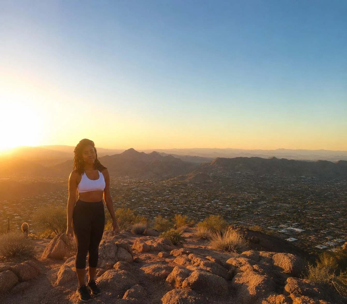 Hiker at the summit of Camelback Mountain overlooking the Phoenix metropolitan area.