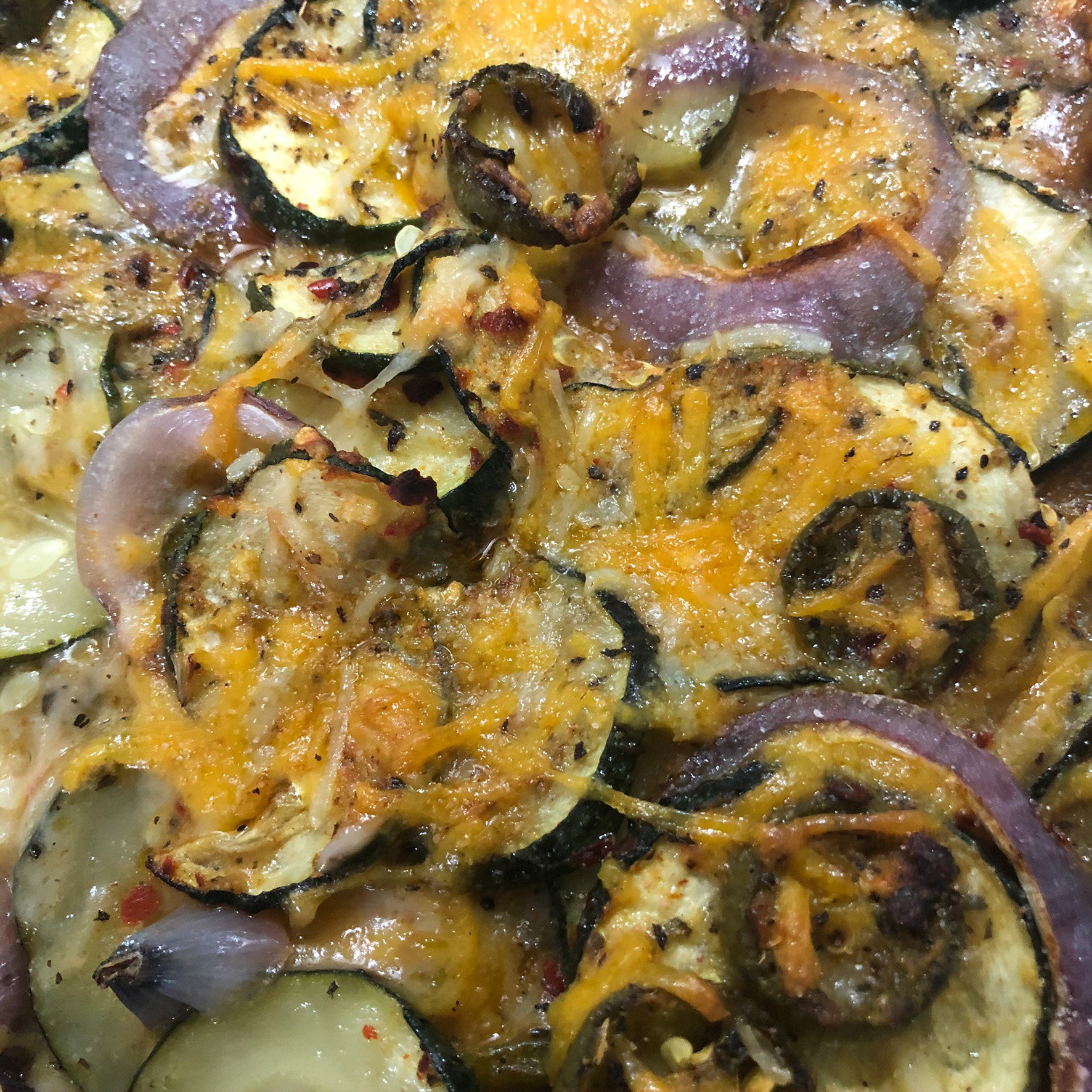 Spicy zucchini casserole baked with peppers and melted vegan cheese