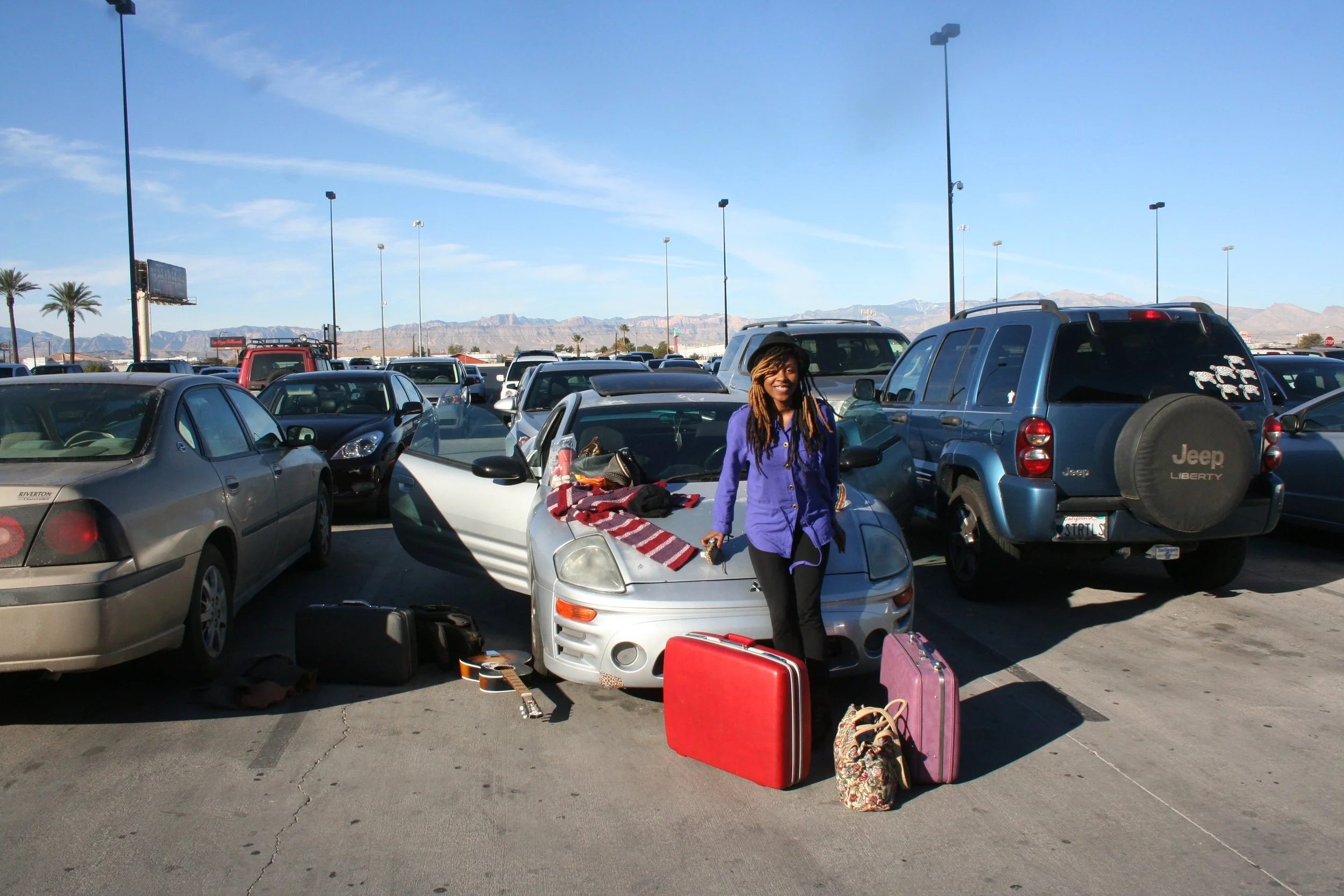 Arriving in Las Vegas during my first trip with luggage beside the car and mountains in the background.