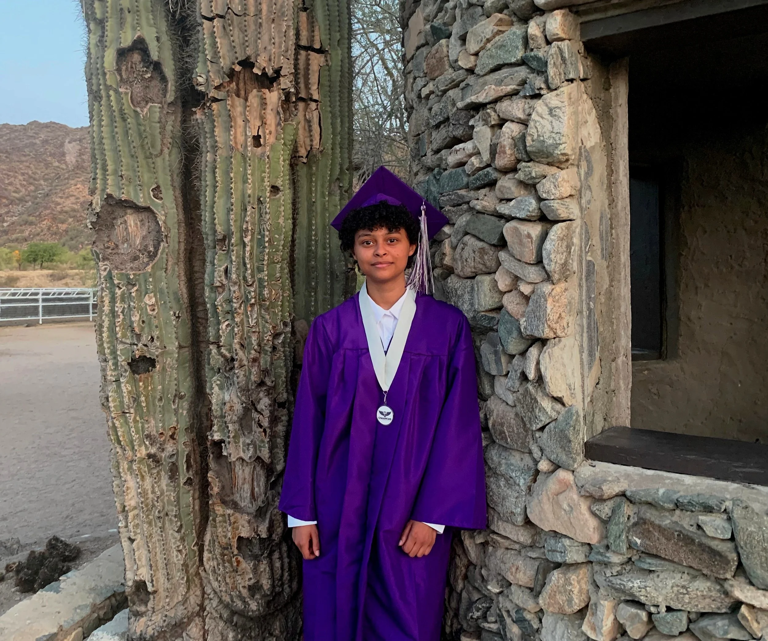 Graduate standing beside the aging saguaro and stone ruins at Scorpion Gulch in Phoenix, Arizona, in 2022.