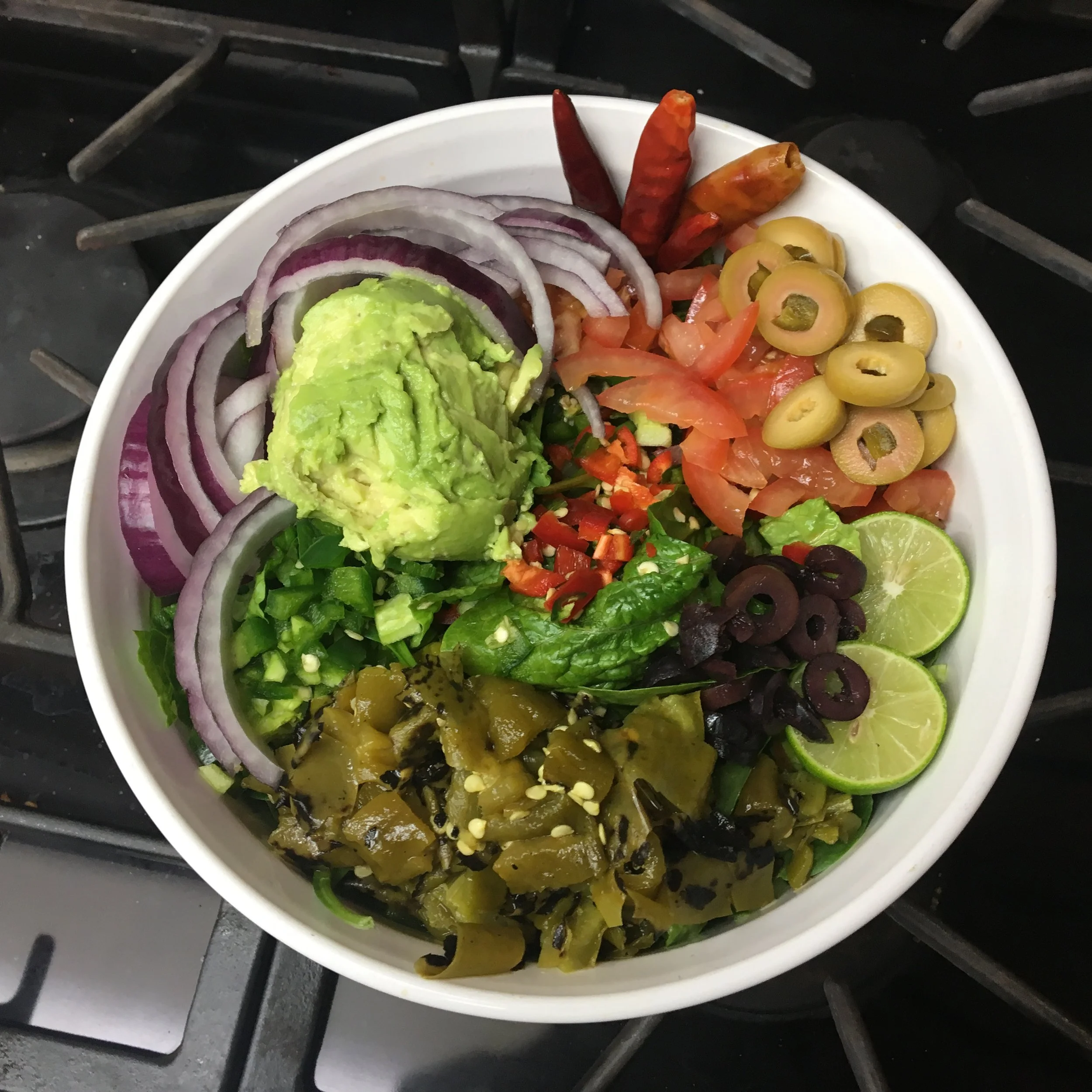 Homemade vegan salad topped with sweet peppers, fresh vegetables, and a variety of colorful toppings.