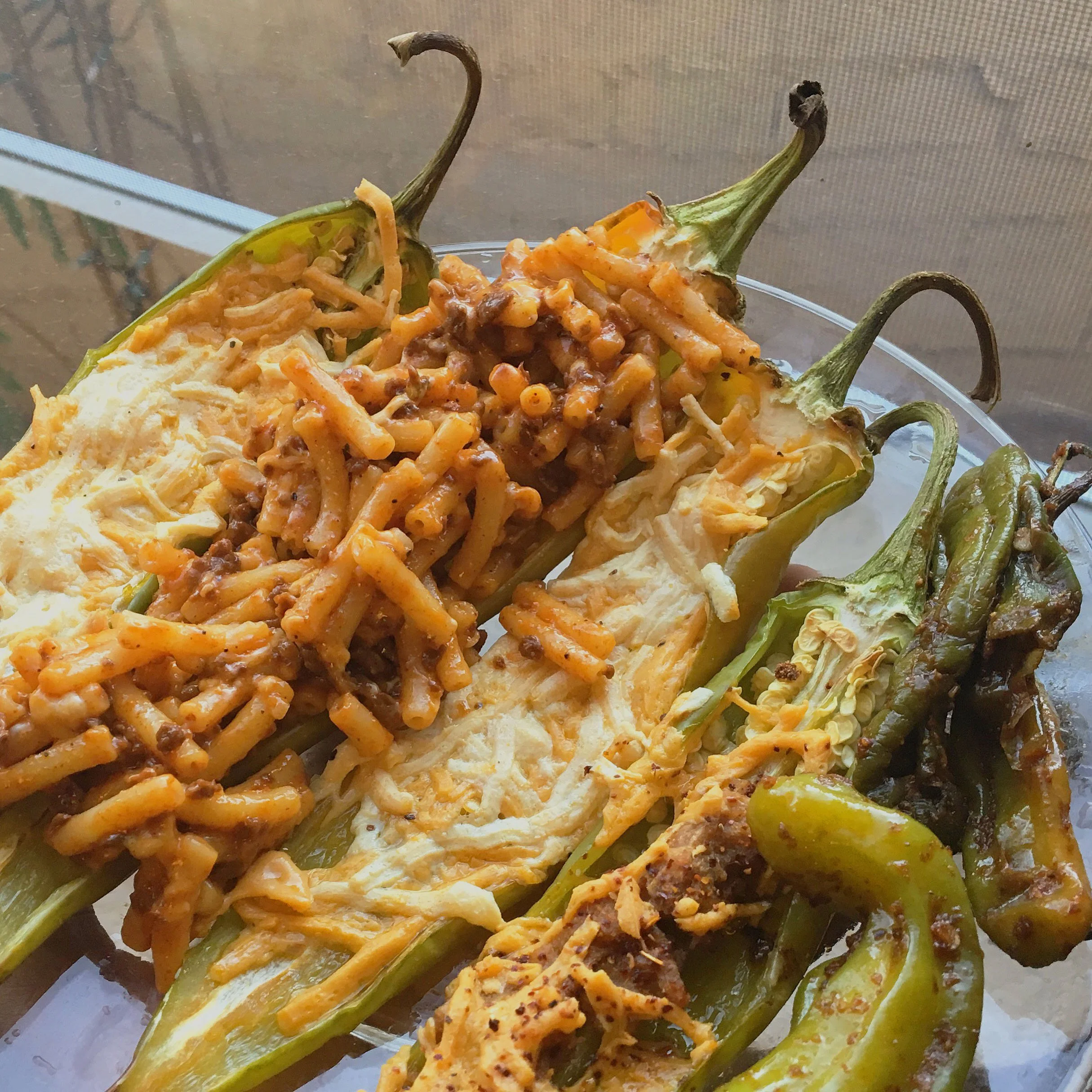 Roasted Hatch chile peppers topped with vegan cheese and macaroni for a Southwest-inspired comfort food dish.