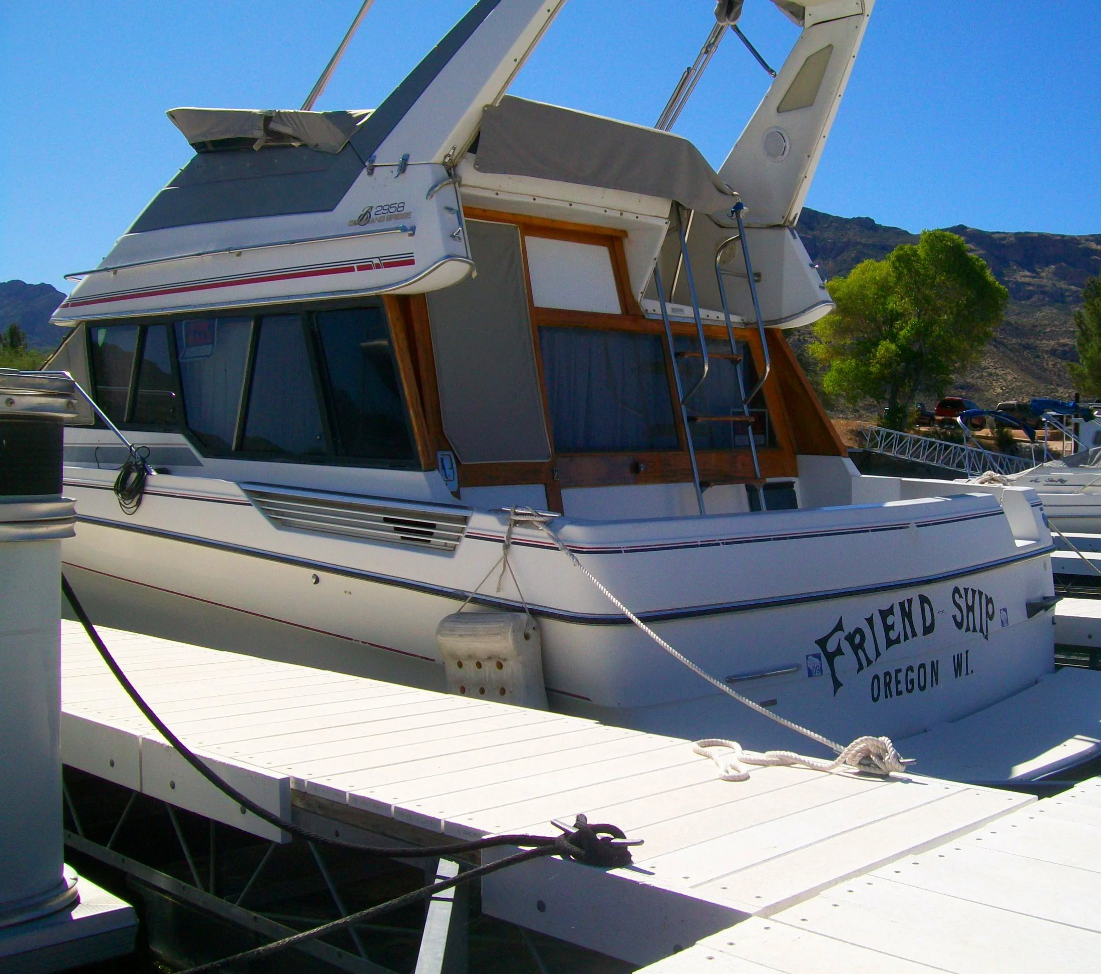 Houseboat docked at Apache Lake Marina with the surrounding Superstition Wilderness mountains in the background.