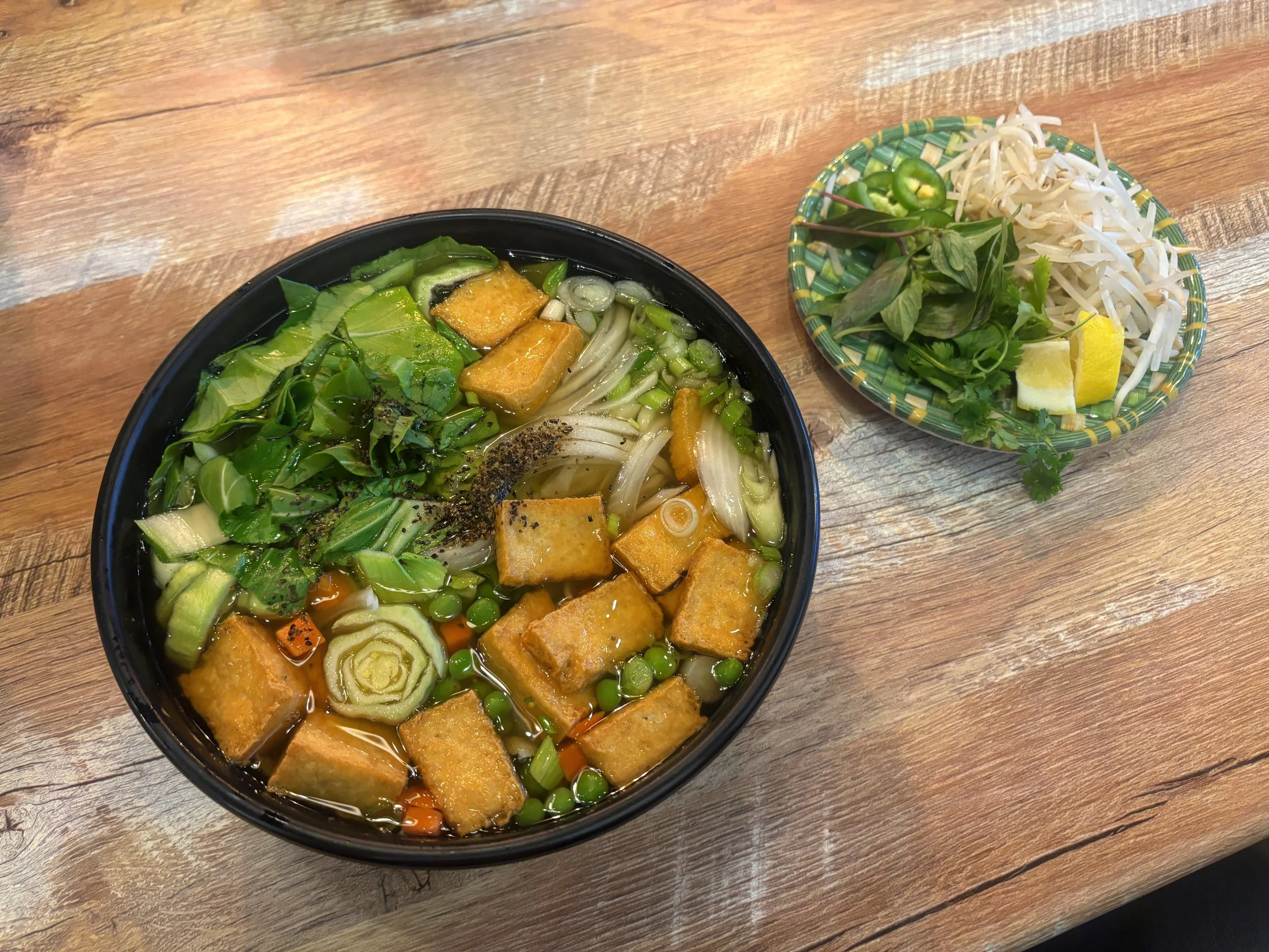 Bowl of vegan pho at Saigon Grub in Casa Grande, Arizona, featuring rice noodles, vegetables, and aromatic Vietnamese broth.
