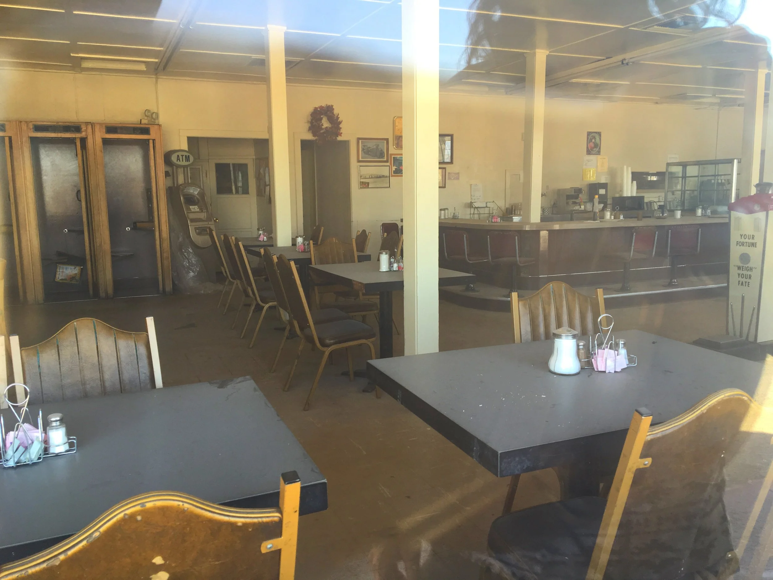 Interior view of the Desert Center Cafe dining room with tables, counter seating, and vintage furnishings.