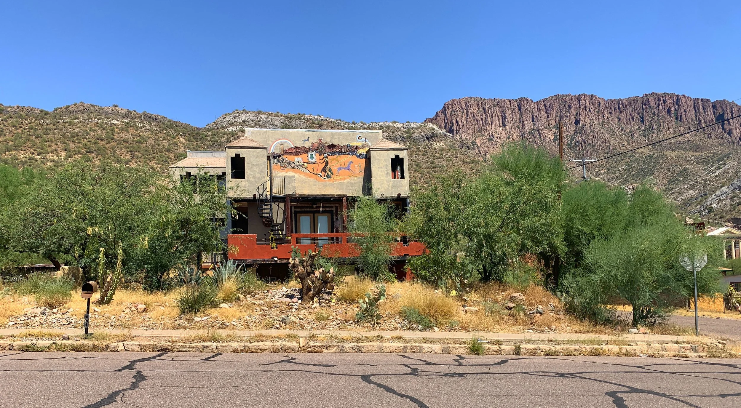 An abandoned home in Superior, Arizona with graffiti and mountain view.