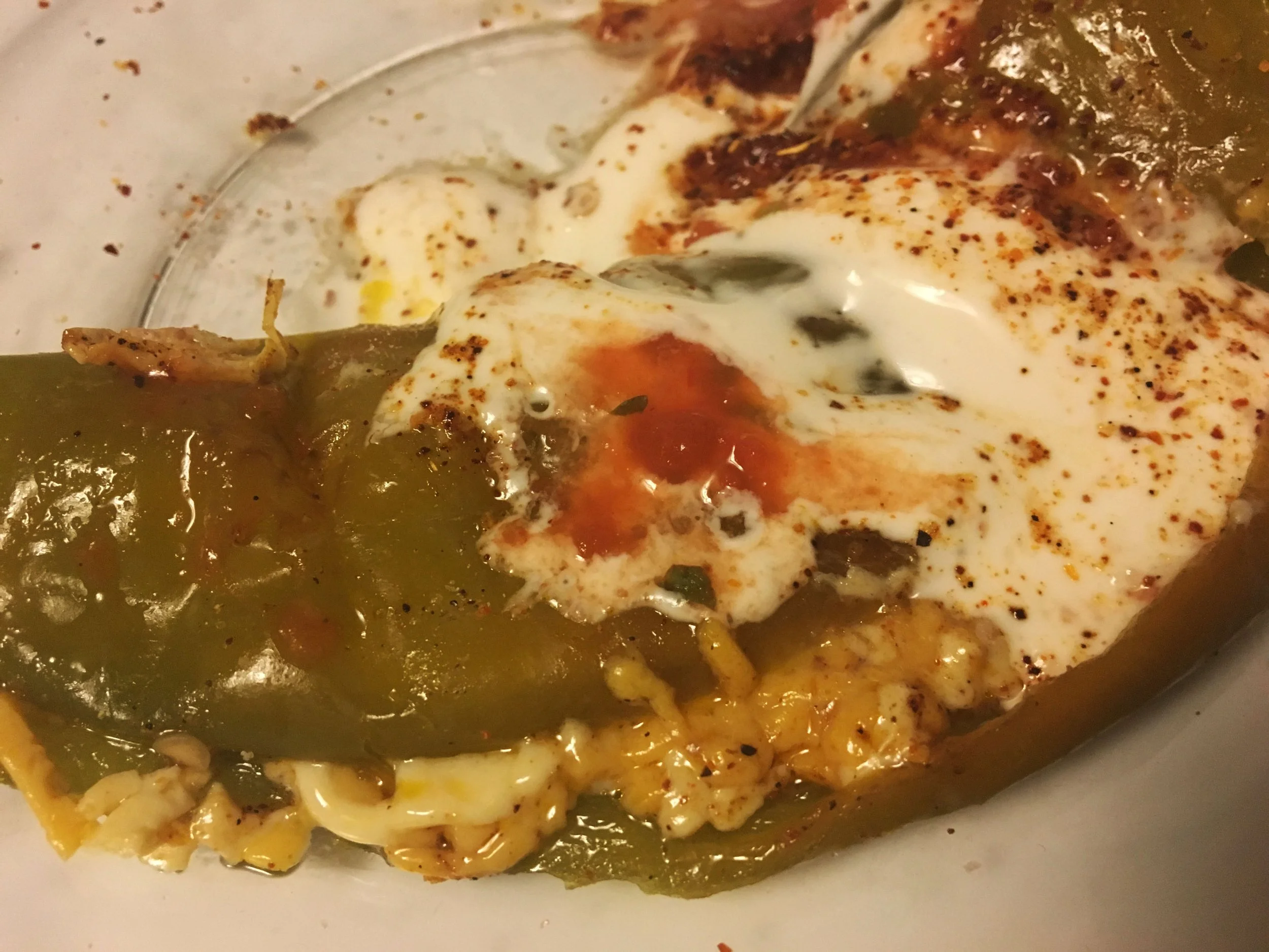 Baked Hatch chile pepper smothered in melted vegan cheese and served as a Southwest-inspired appetizer.