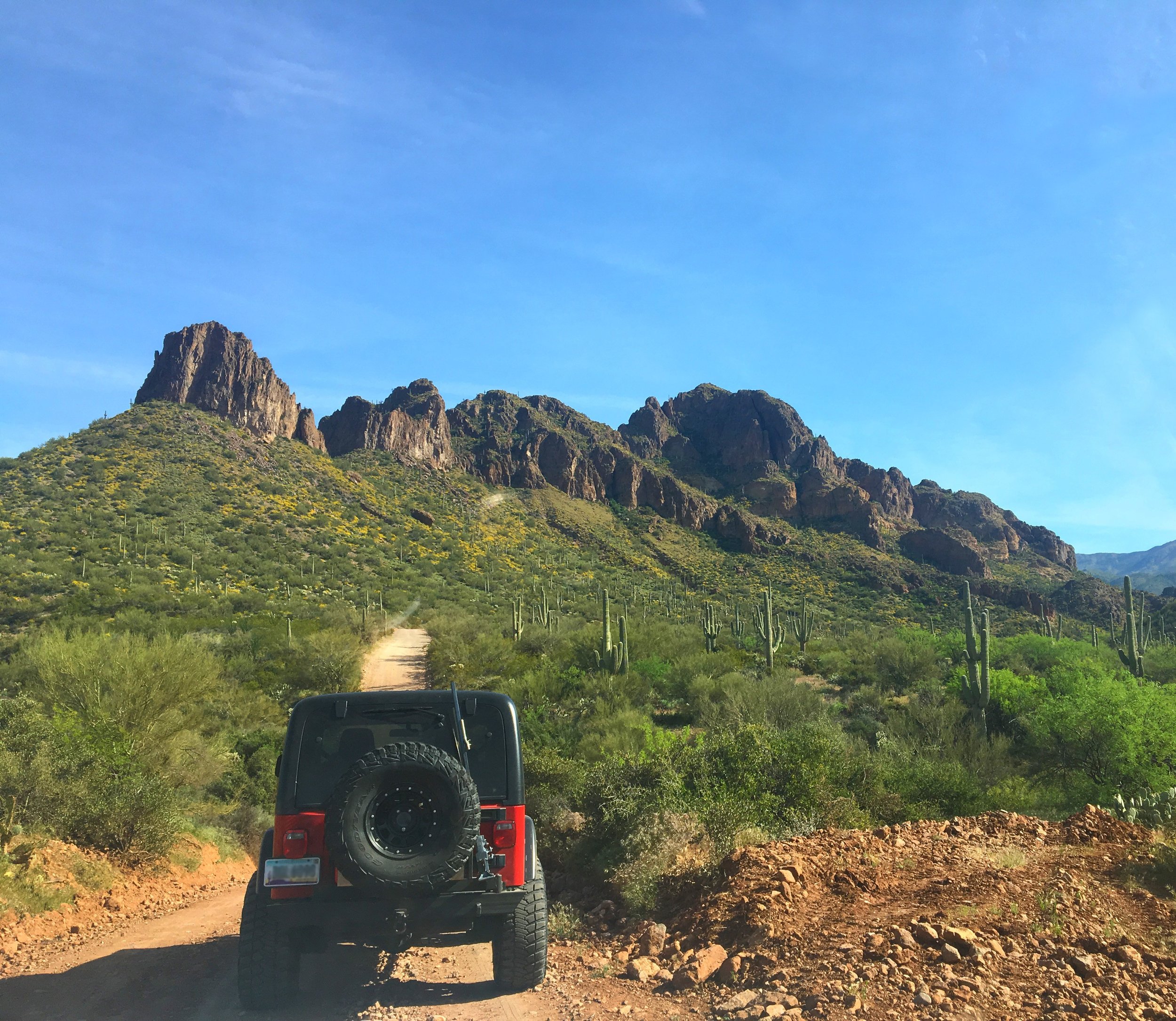 Jeep driving along the dusty dirt road of Montana Mountain Loop Trail, Arizona.