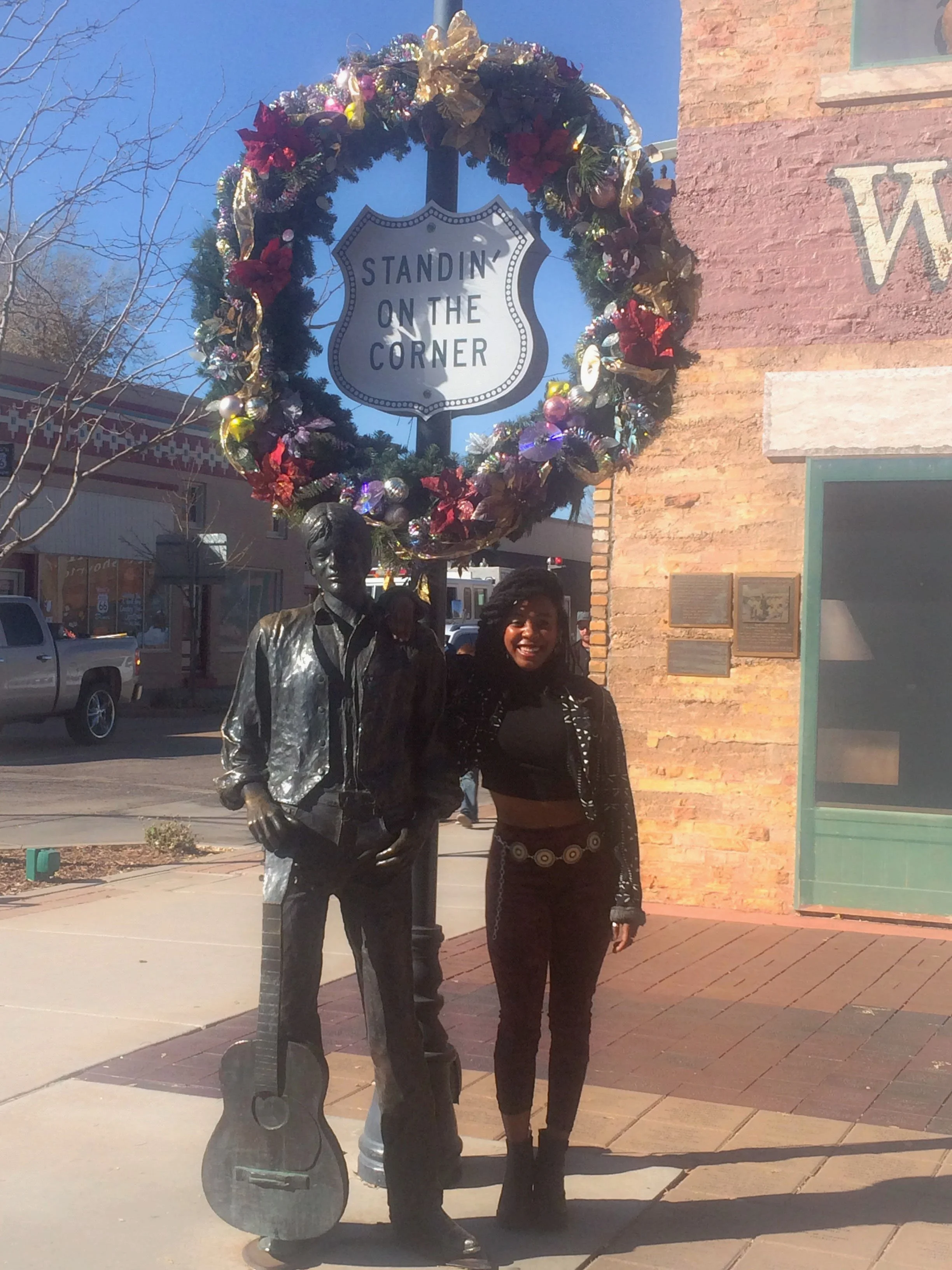 Traveler standing next to the statue of "Easy" at the Standin’ on the Corner Park in Winslow, Arizona
