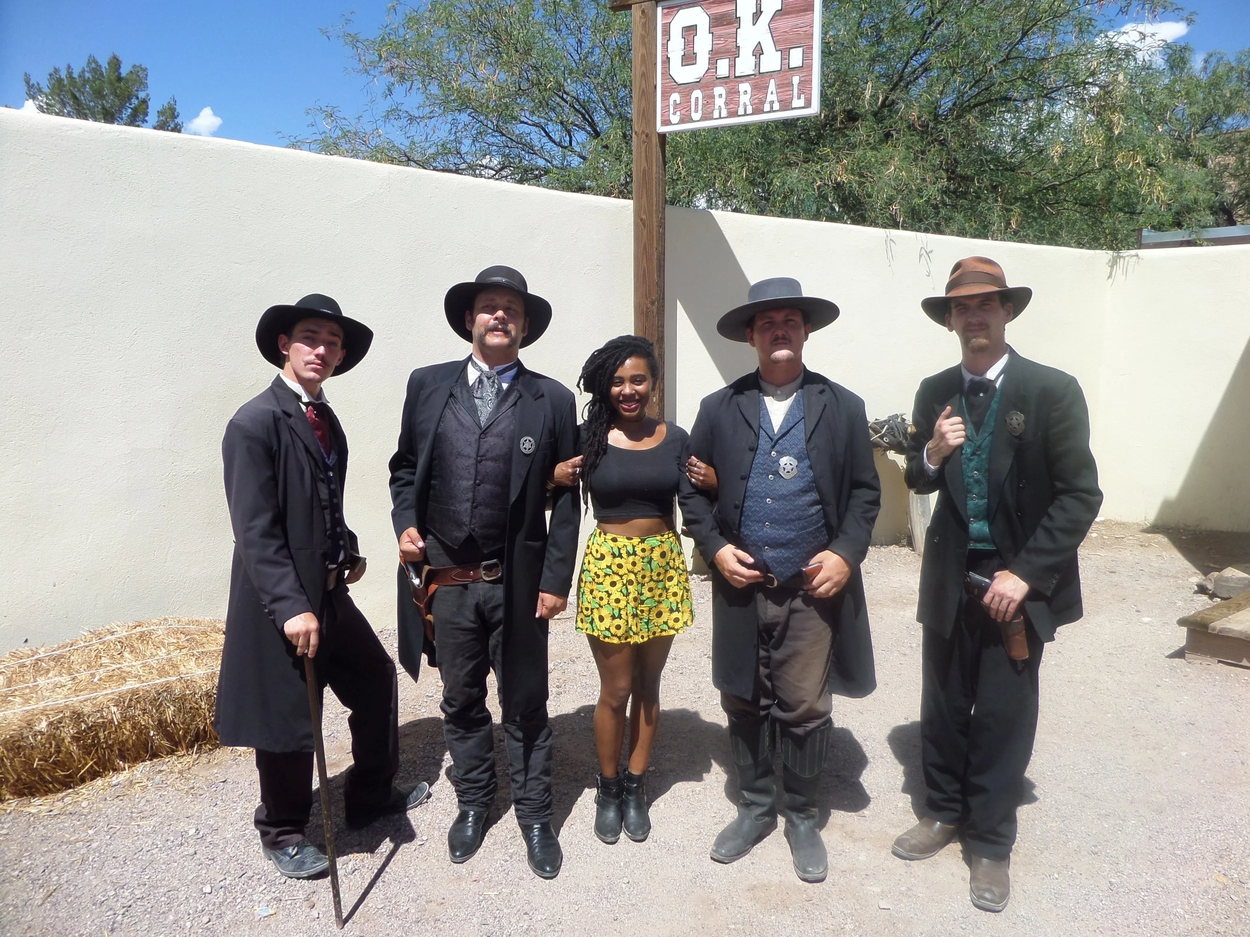 Visitor standing with actors portraying Old West figures at the OK Corral in Tombstone, Arizona