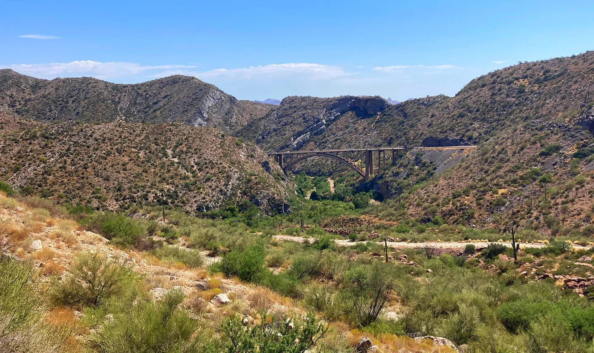 A scenic view of the Queen Creek Arch Bridge with desert landscape in Superior, Arizona.