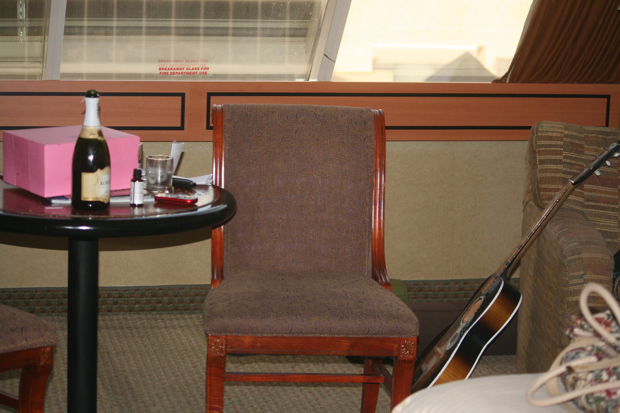 Hotel room in Las Vegas with Ronald's Donuts, a guitar, and travel belongings after arriving.